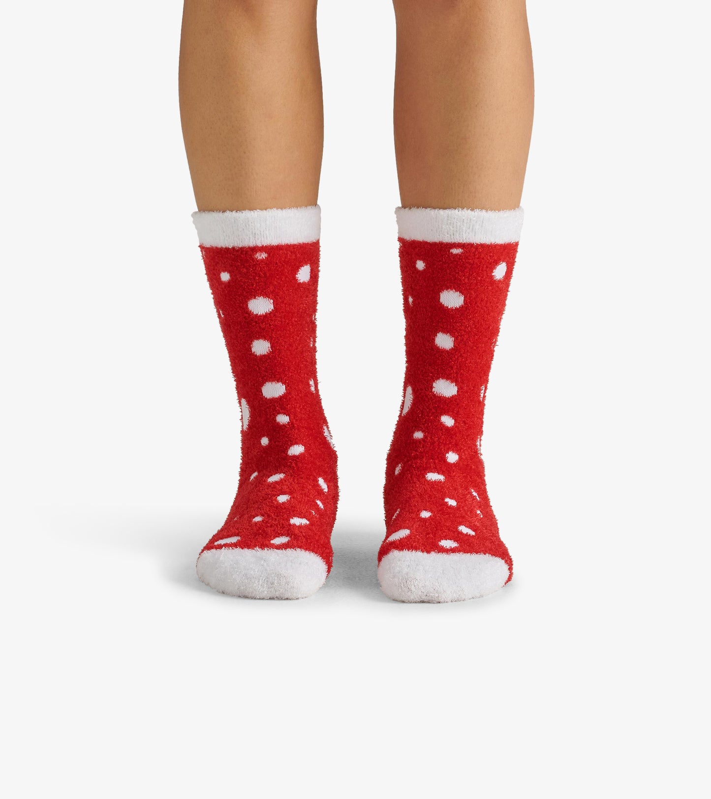 Red fuzzy socks with white polka dots and a white cuff, designed for warmth and comfort.
