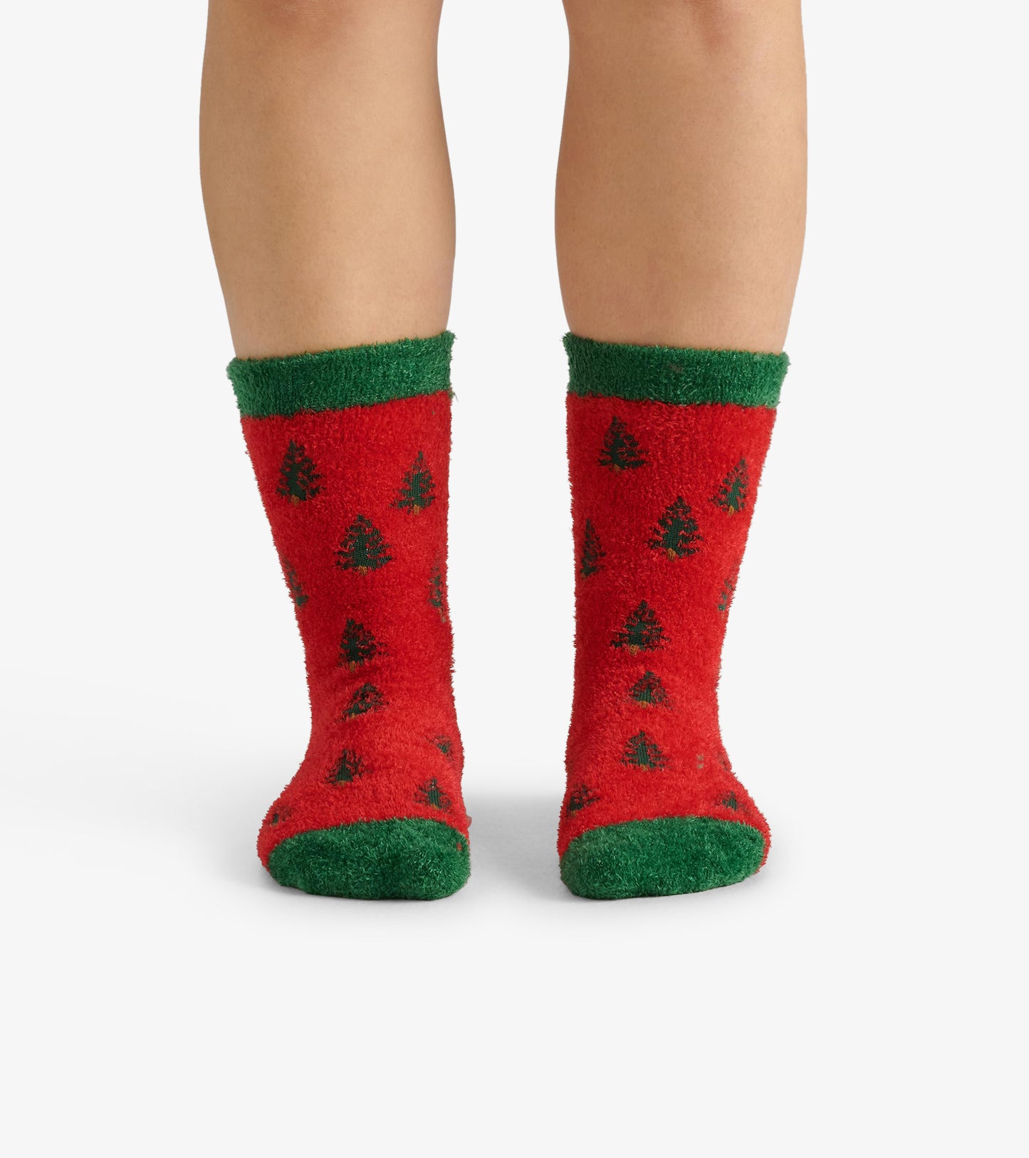 Red fuzzy socks with green cuffs, featuring a pattern of black trees, designed for adults.