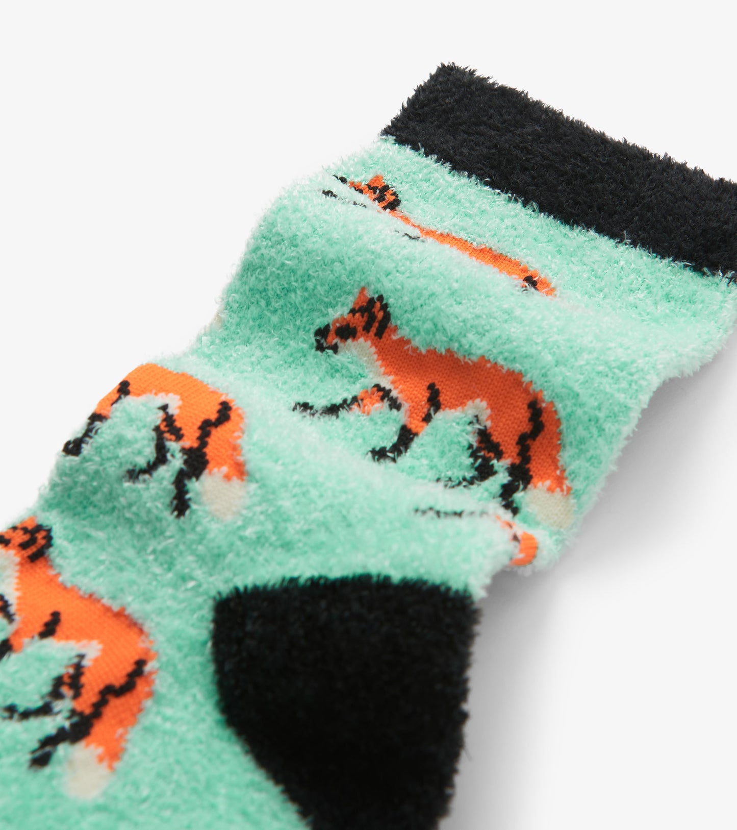 Fuzzy mint green socks featuring orange fox patterns and a black cuff, ideal for cozy wear.