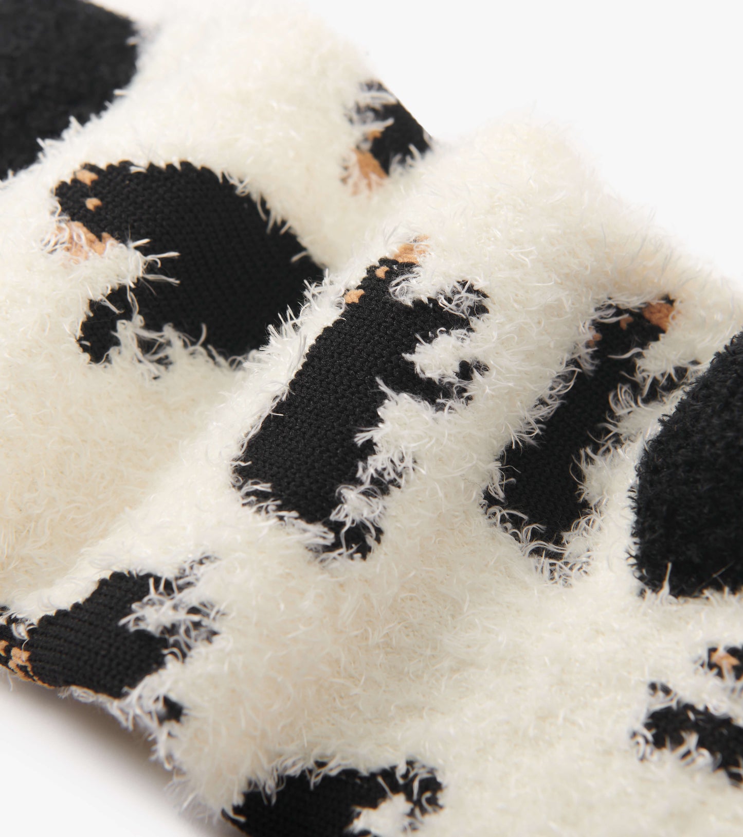 Fuzzy black and white socks featuring a bear pattern, designed for comfort and warmth. One size fits most.