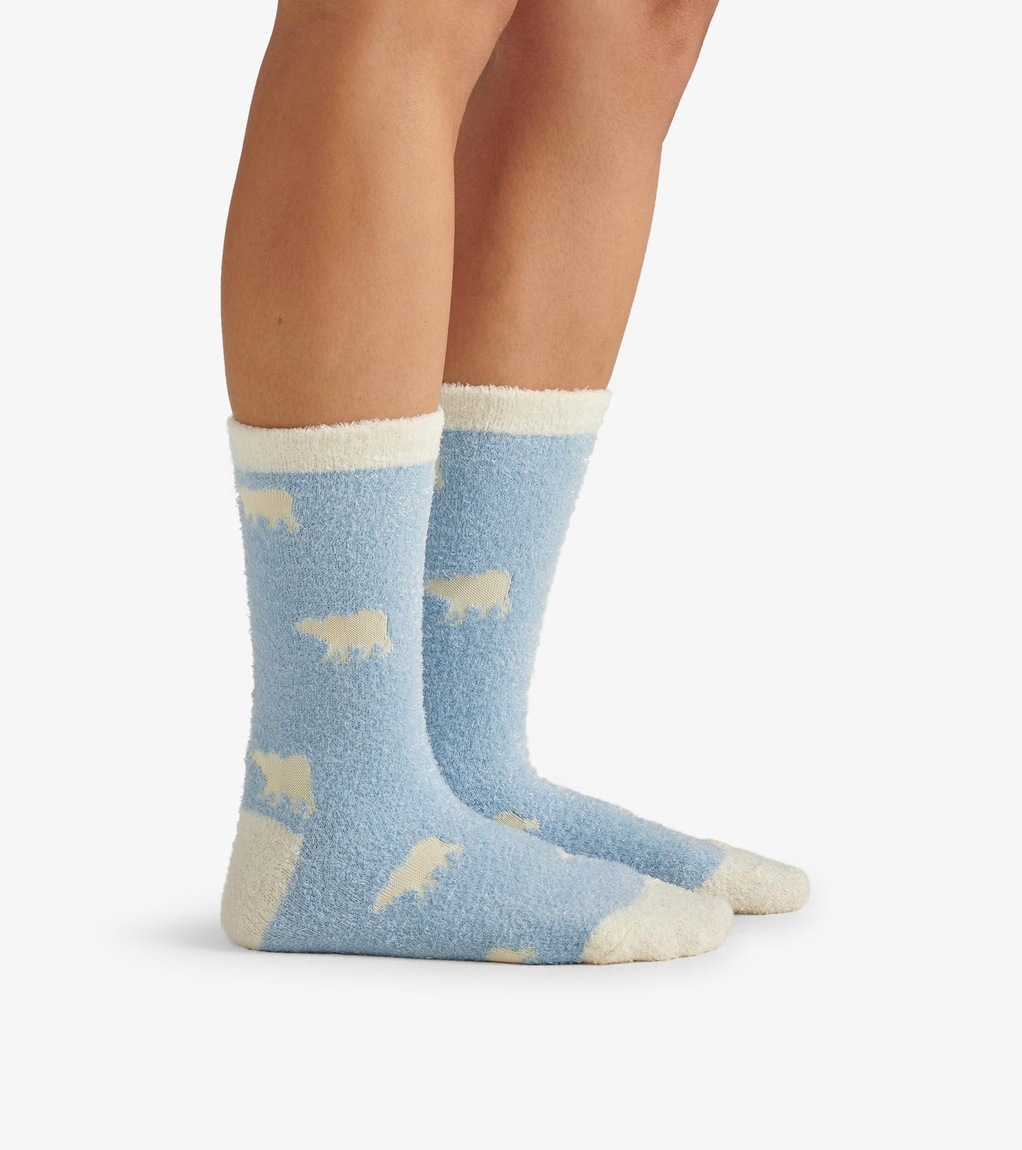 Fuzzy blue socks featuring white polar bear patterns and a cream-colored cuff, designed for comfort and warmth.