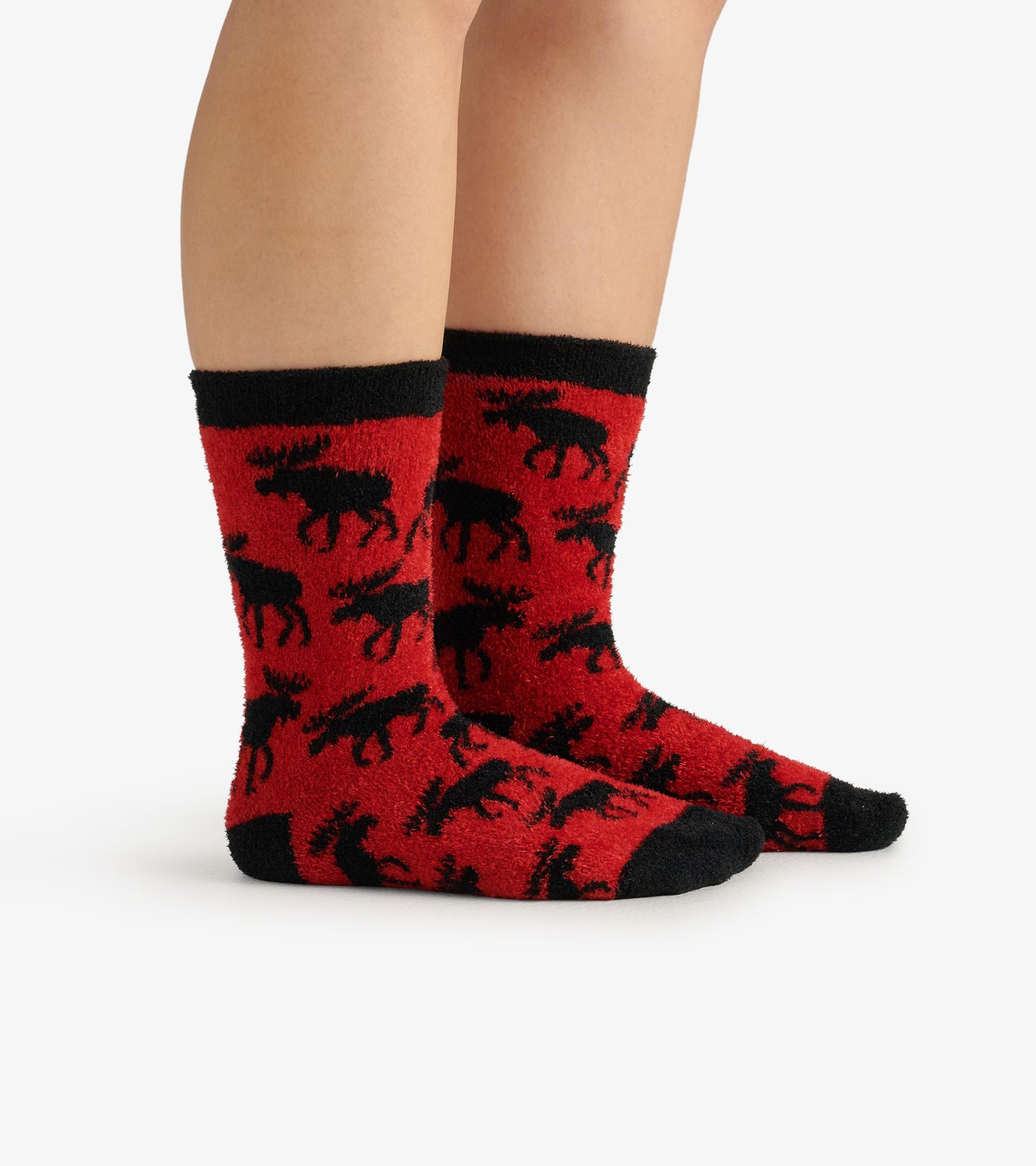 Red fuzzy socks featuring black moose patterns and black cuffs, designed for warmth and comfort.
