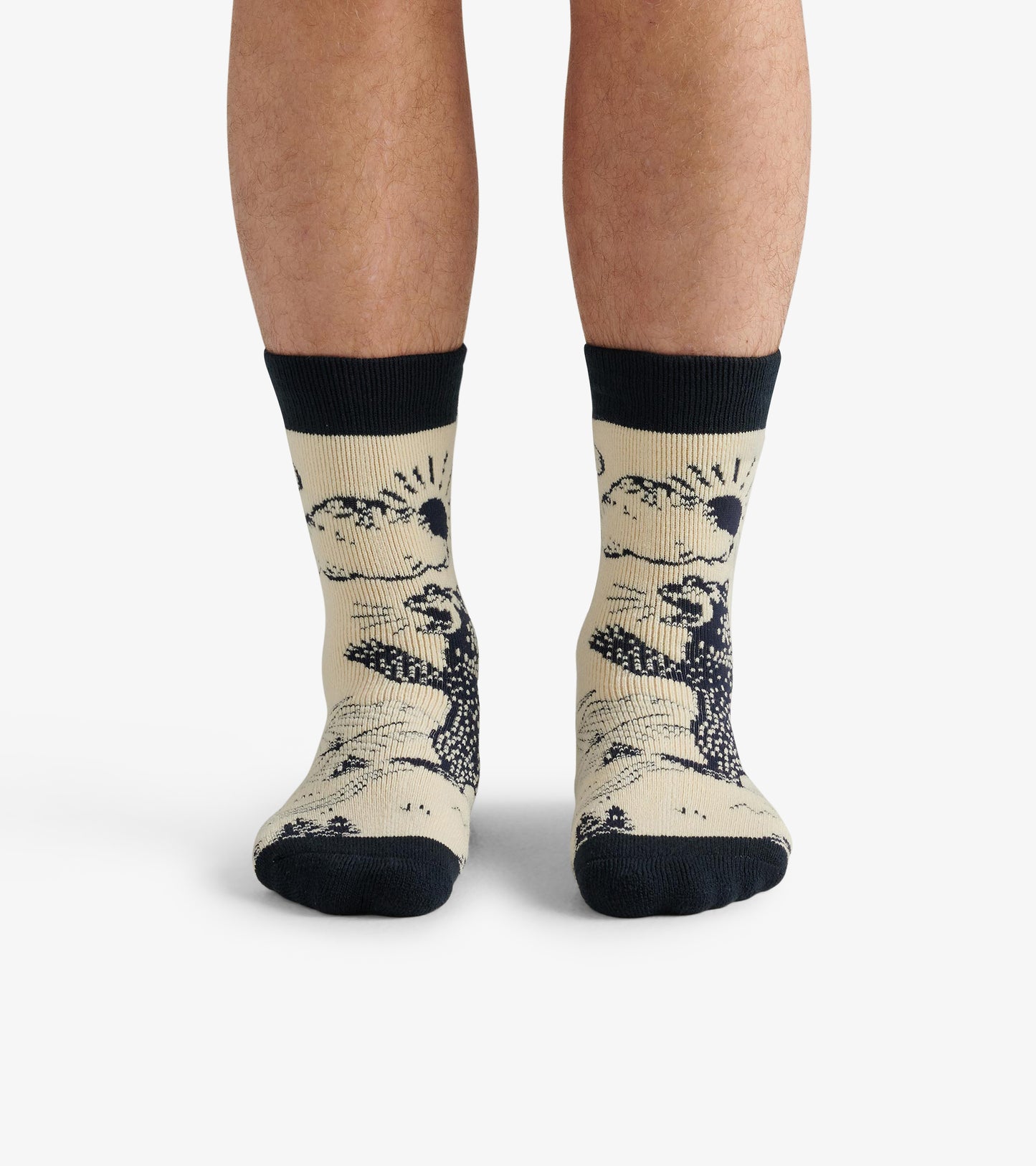 Beige cozy socks featuring a black bear design and dark ribbed cuffs, worn on bare feet.