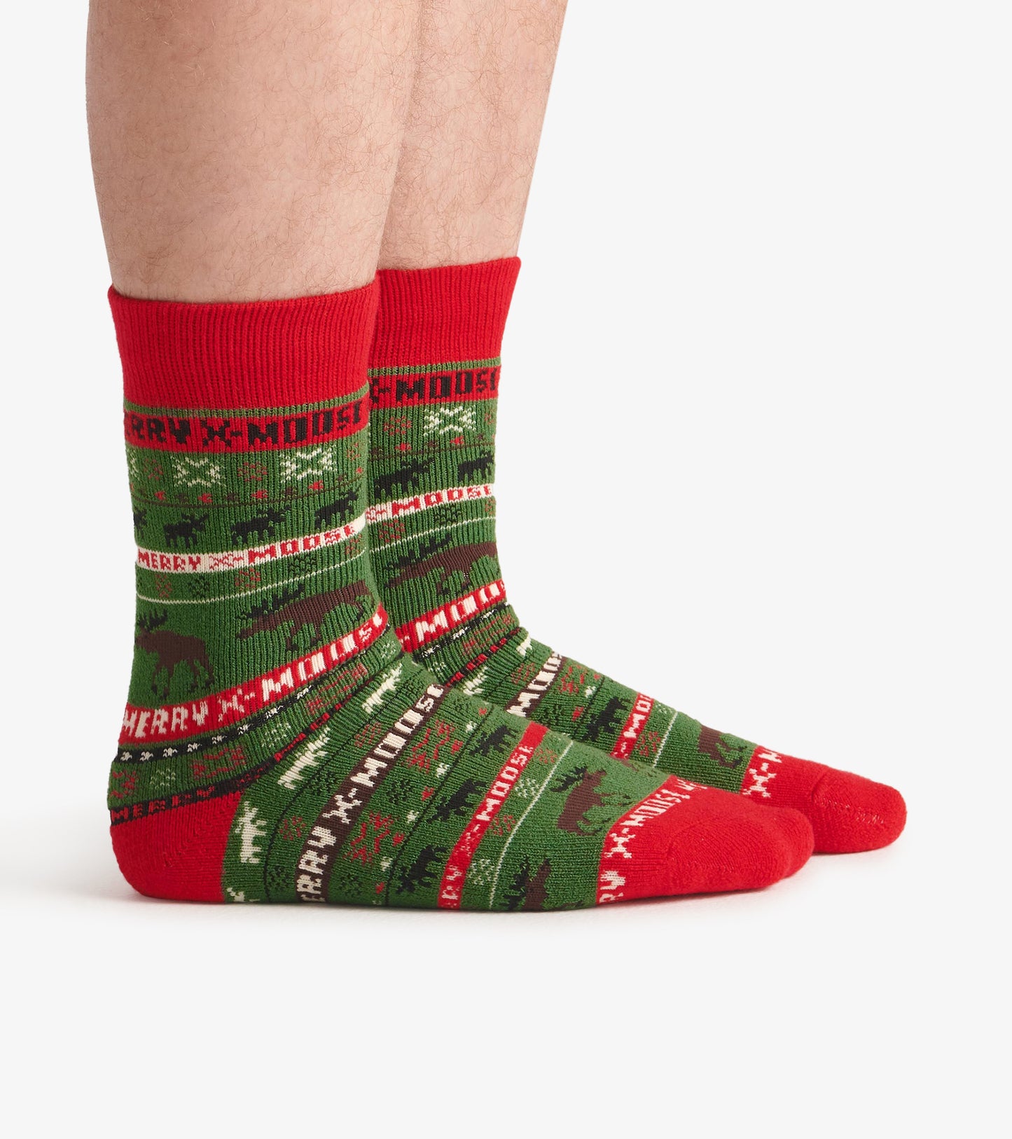 Green and red cozy socks featuring a festive moose pattern and "MERRY X-MOOSE" text, suitable for winter wear.