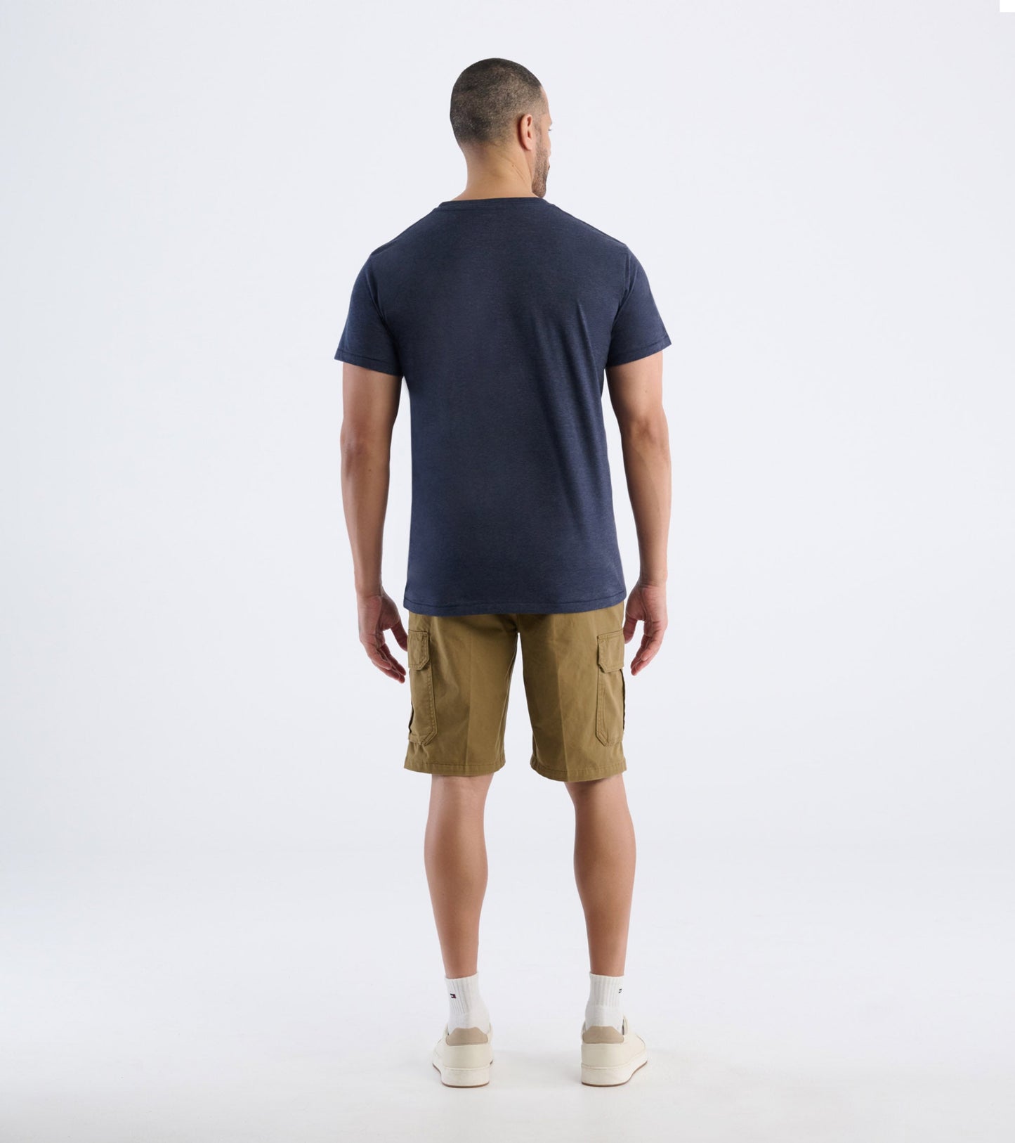 Men's navy blue short-sleeve tee, viewed from the back, paired with khaki cargo shorts.