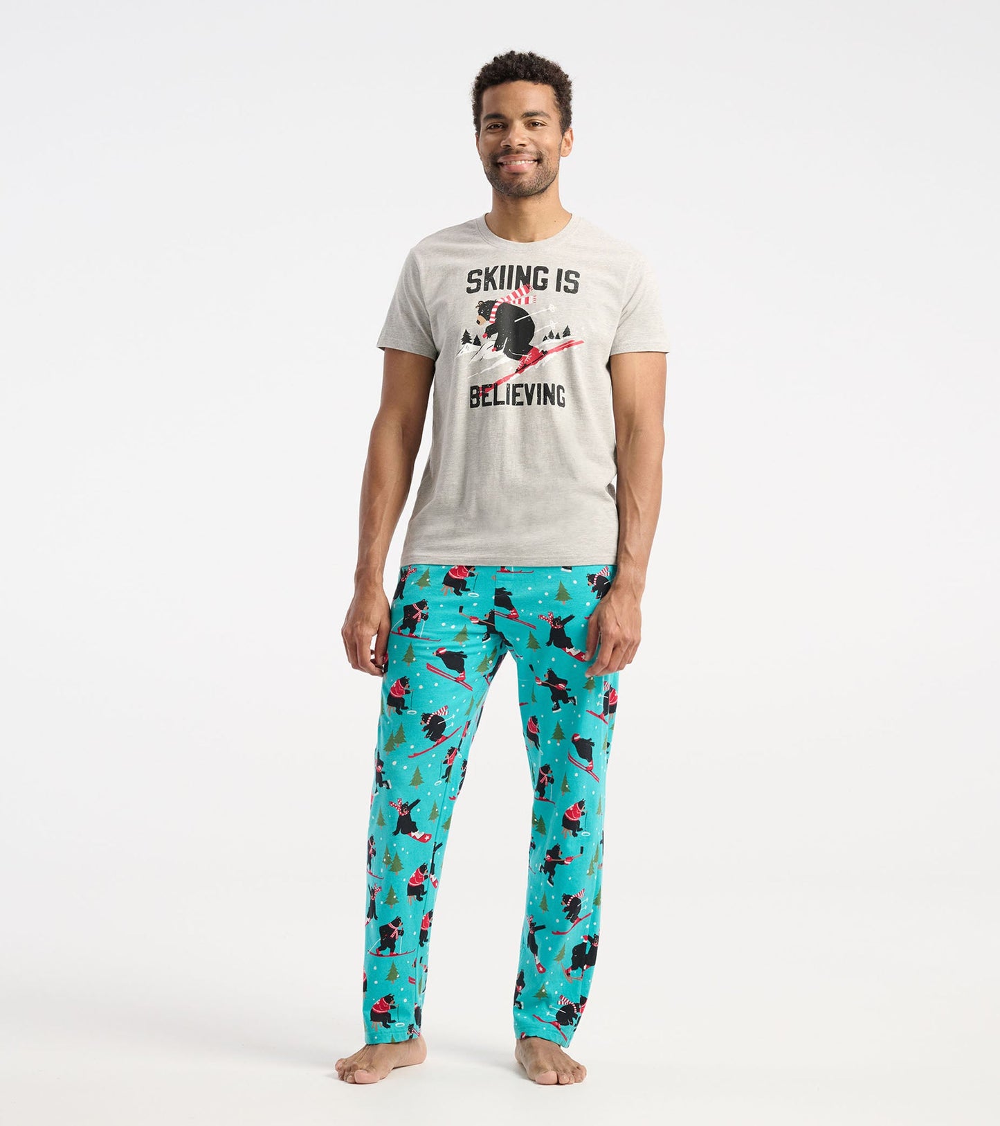 Gray short-sleeve t-shirt with a skiing graphic, paired with colorful pajama pants featuring a playful winter pattern.