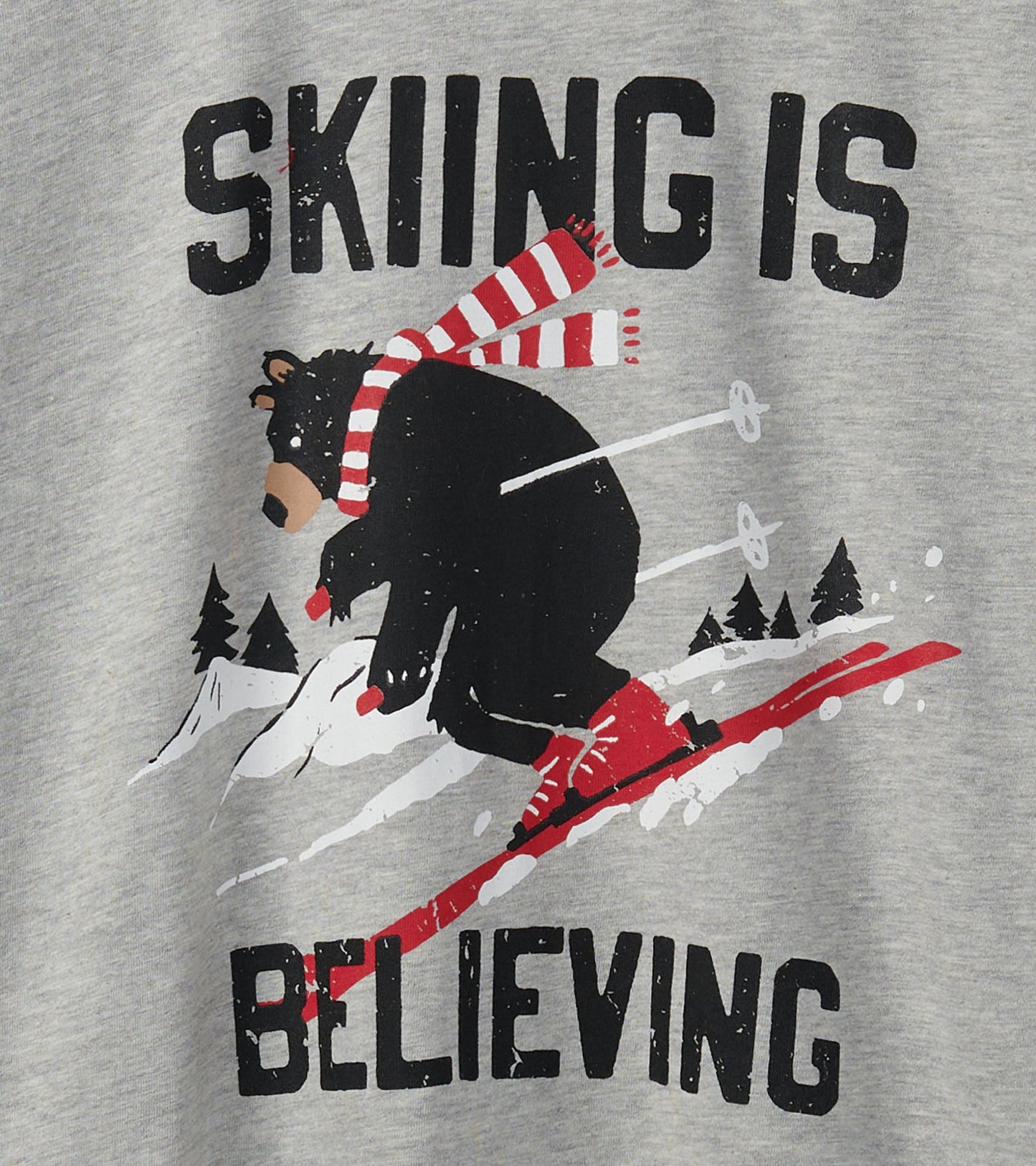 Gray t-shirt featuring a graphic of a bear skiing with the text "SKIING IS BELIEVING" in bold letters.
