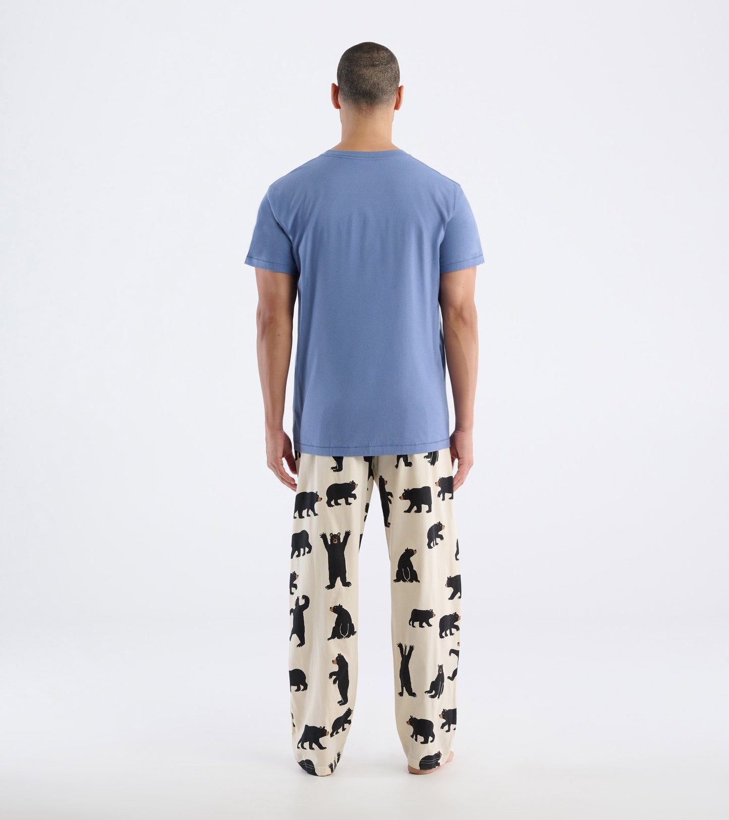 Men's short-sleeve t-shirt in light blue, worn with patterned pajama pants featuring black bear silhouettes.