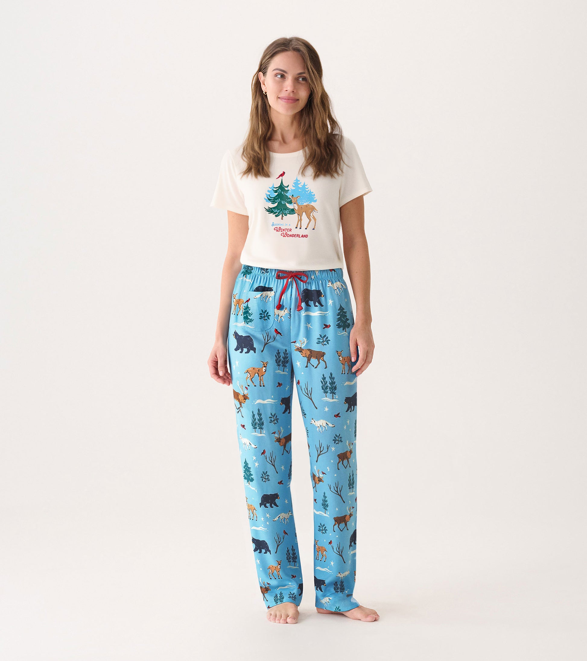 Cream short-sleeve pajama t-shirt with forest design paired with blue pajama pants featuring animal and tree patterns.