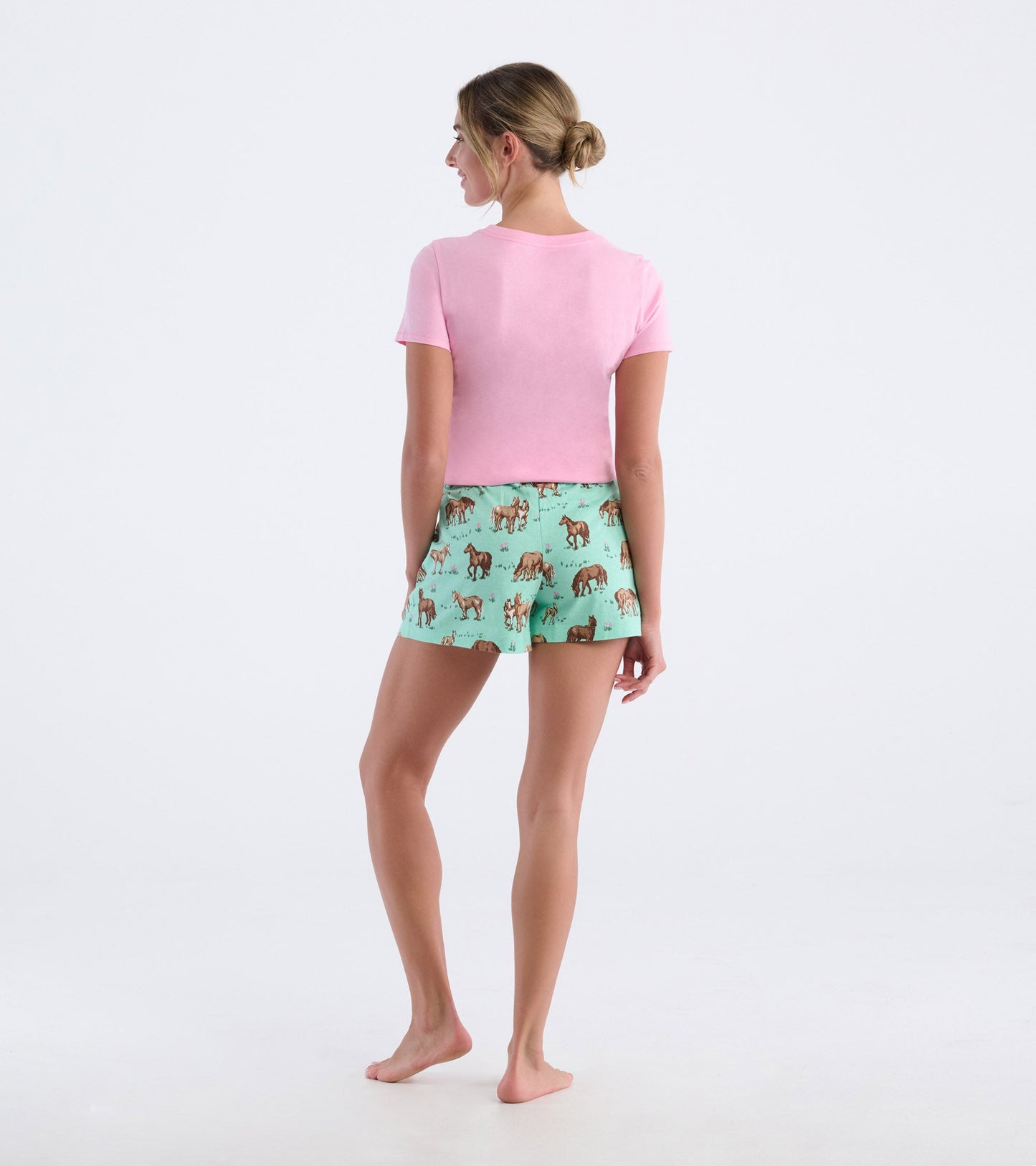 Pink short-sleeve pajama t-shirt paired with mint green shorts featuring a horse print, viewed from the back.