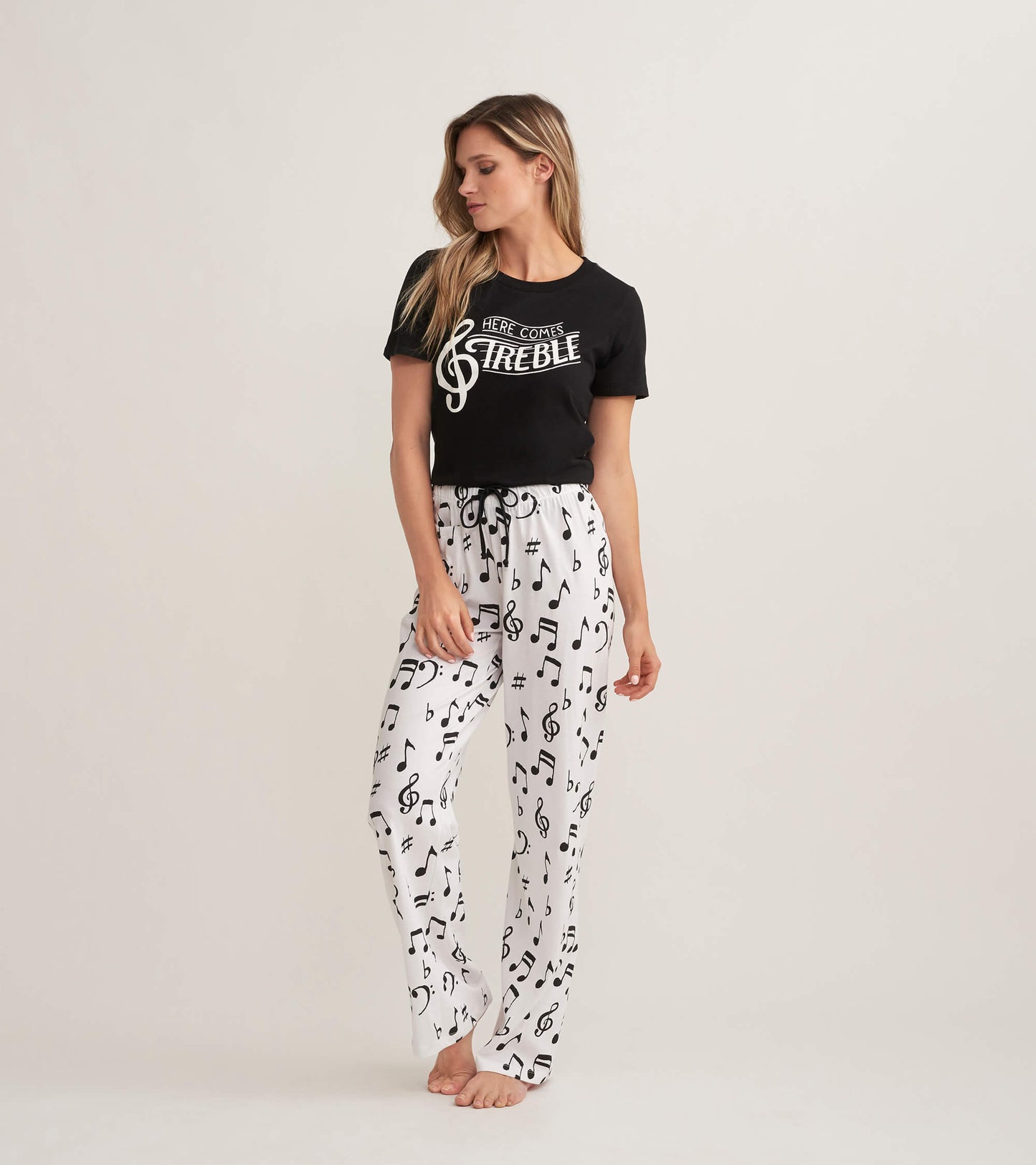 Black short-sleeve pajama t-shirt with white musical note print pants, featuring an elastic waistband.