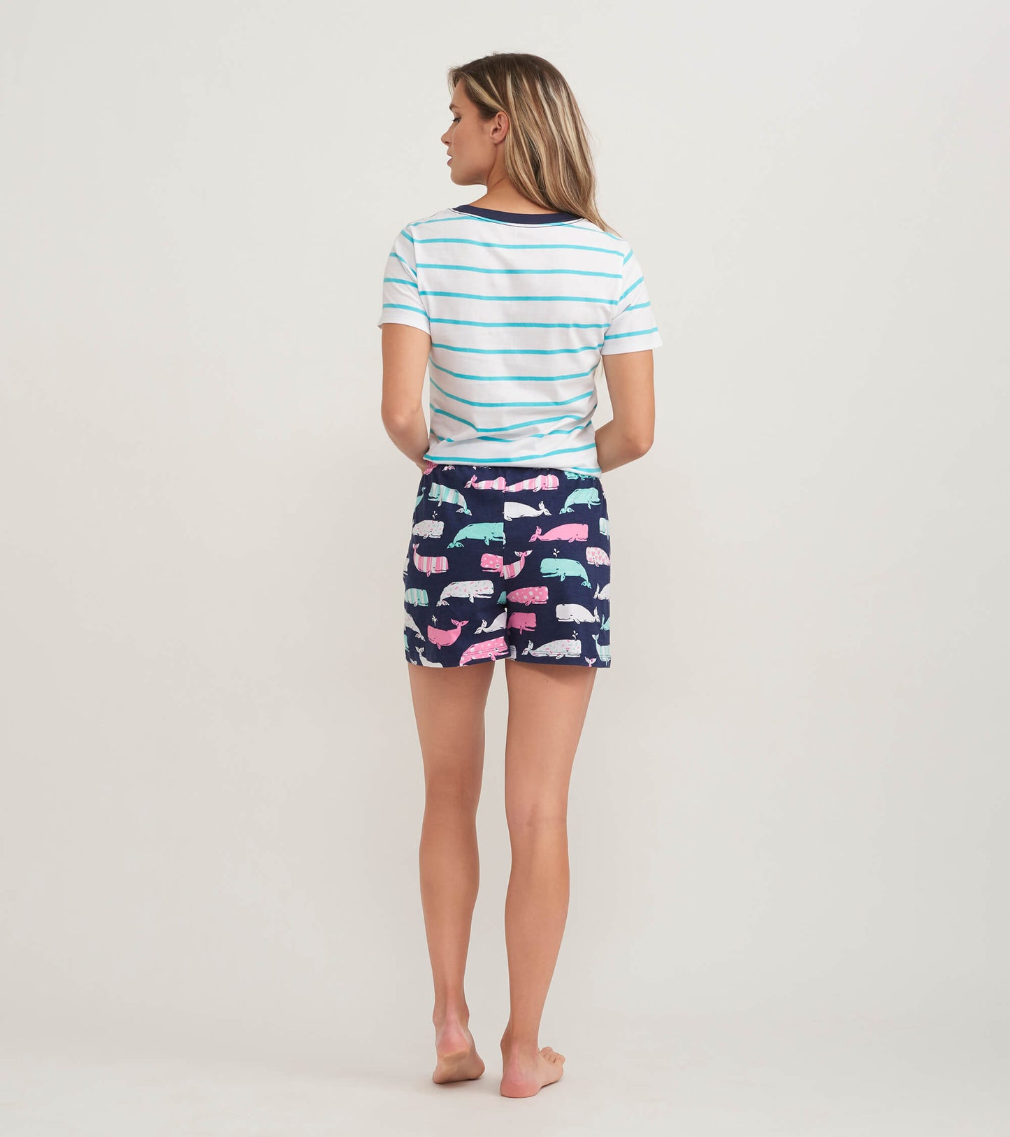 Women's pajama t-shirt featuring blue and white stripes, paired with whale-patterned shorts in navy and pastel colors.