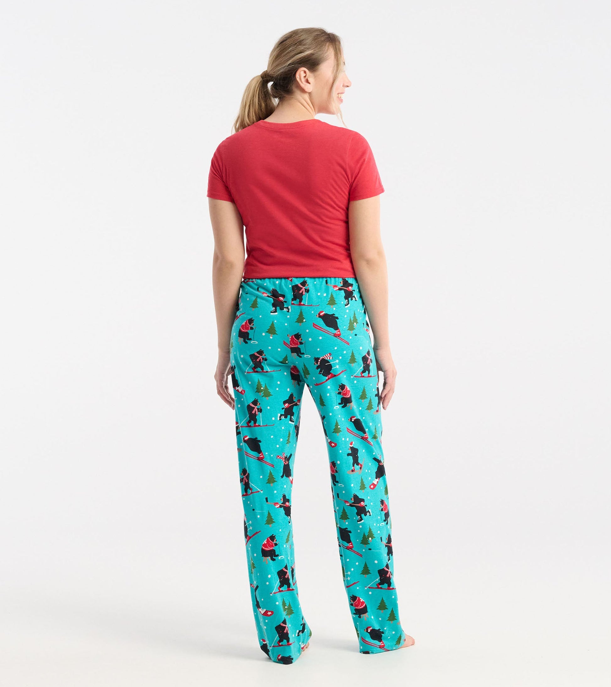 Red short-sleeve pajama tee paired with turquoise pants featuring a skiing pattern and trees, viewed from the back.