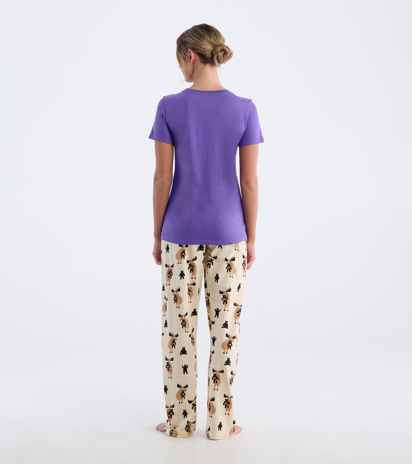 Purple short-sleeve pajama t-shirt paired with cream pants featuring a moose and bear print, viewed from the back.