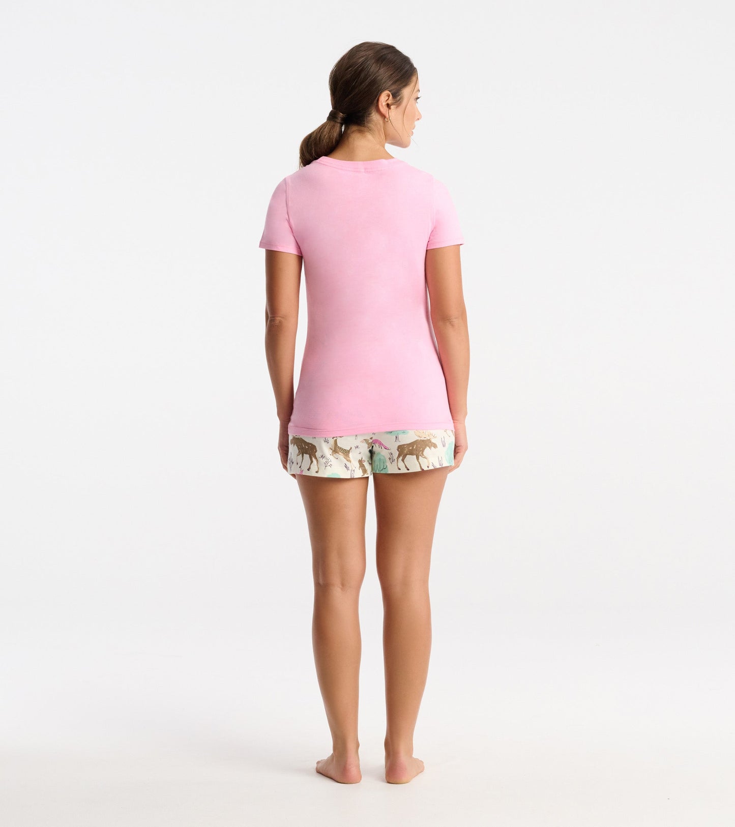 Pink short-sleeve pajama t-shirt, fitted style, worn with patterned shorts featuring animals and nature motifs.