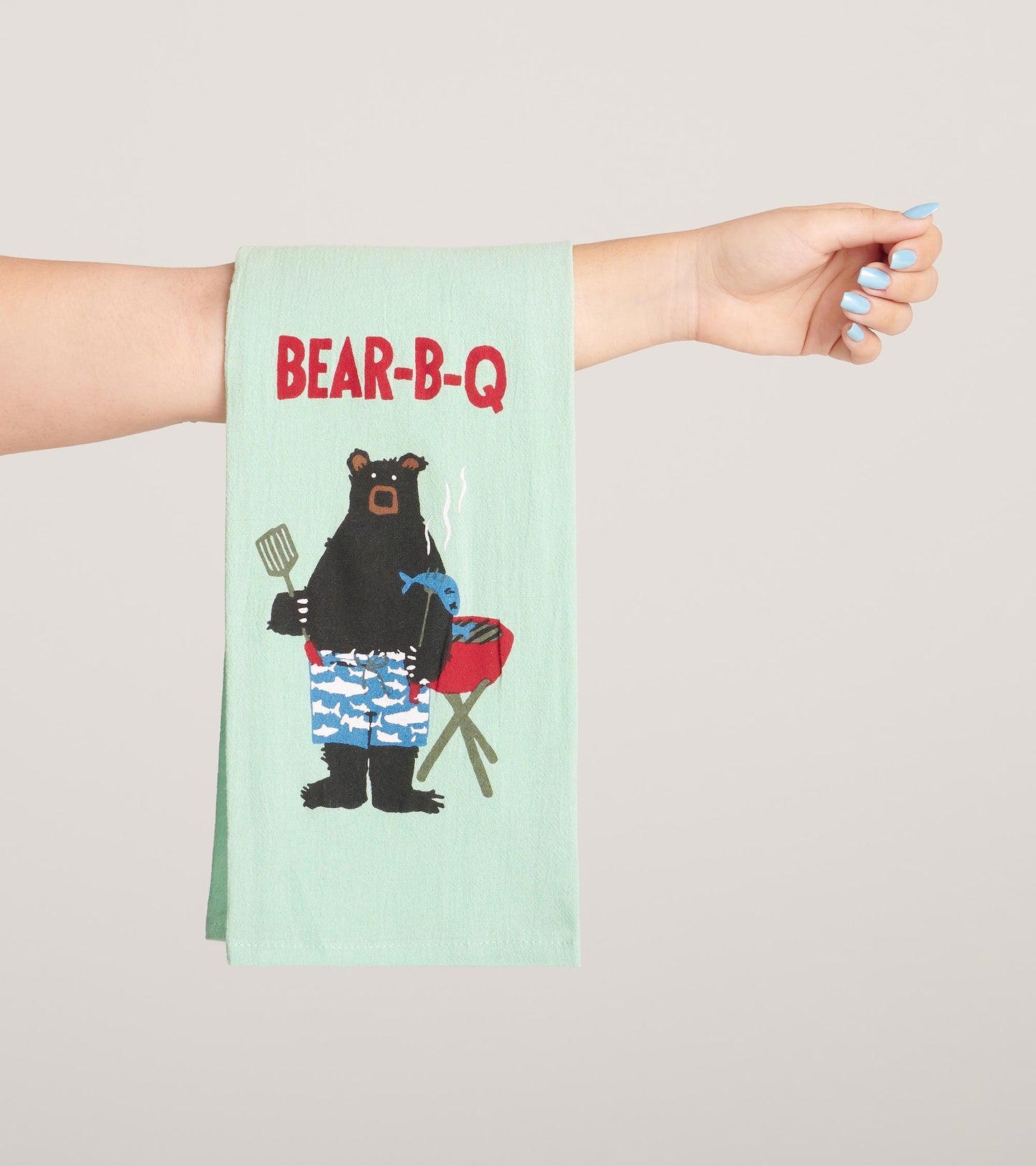 Light green tea towel featuring a bear grilling with the text "BEAR-B-Q" in red. Ideal for kitchen use or as a gift.