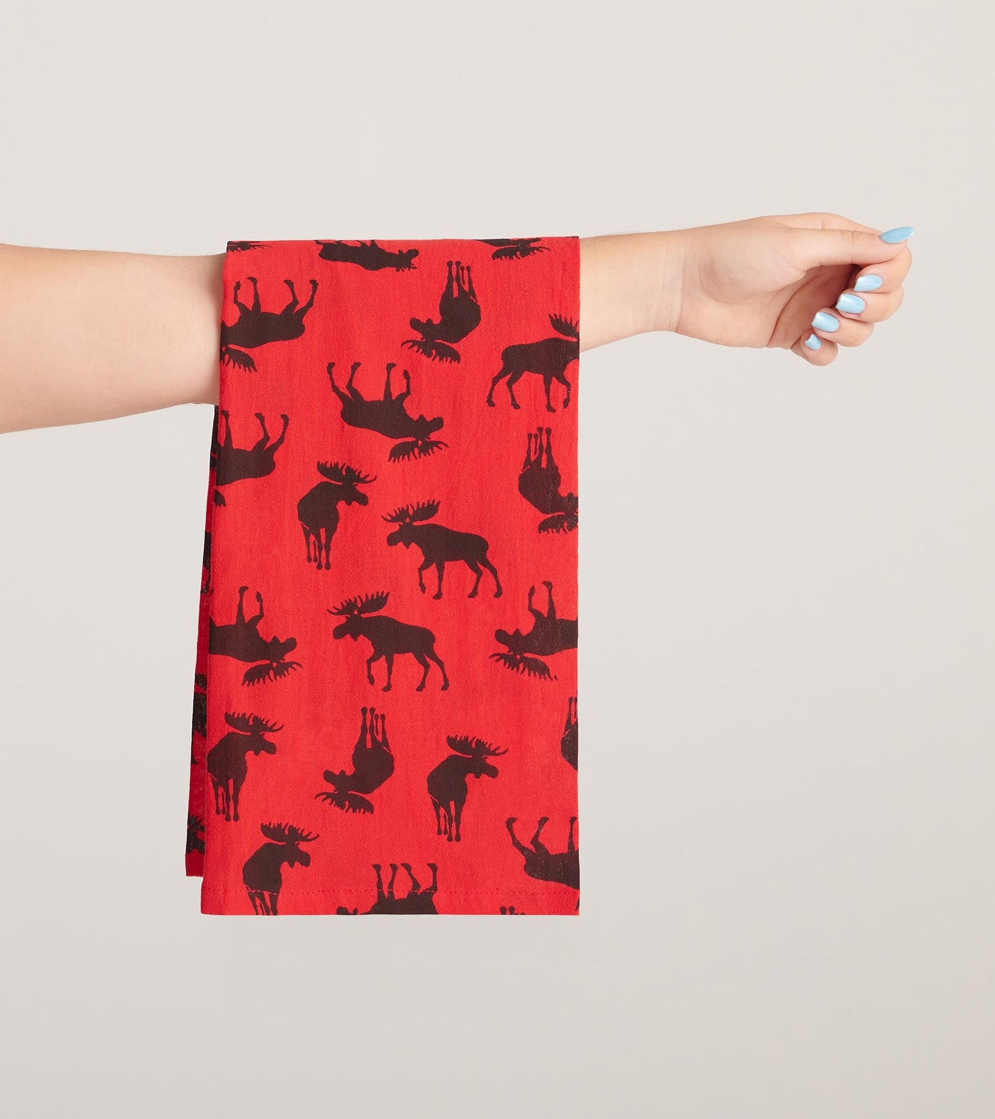 Red tea towel featuring a pattern of black moose silhouettes.