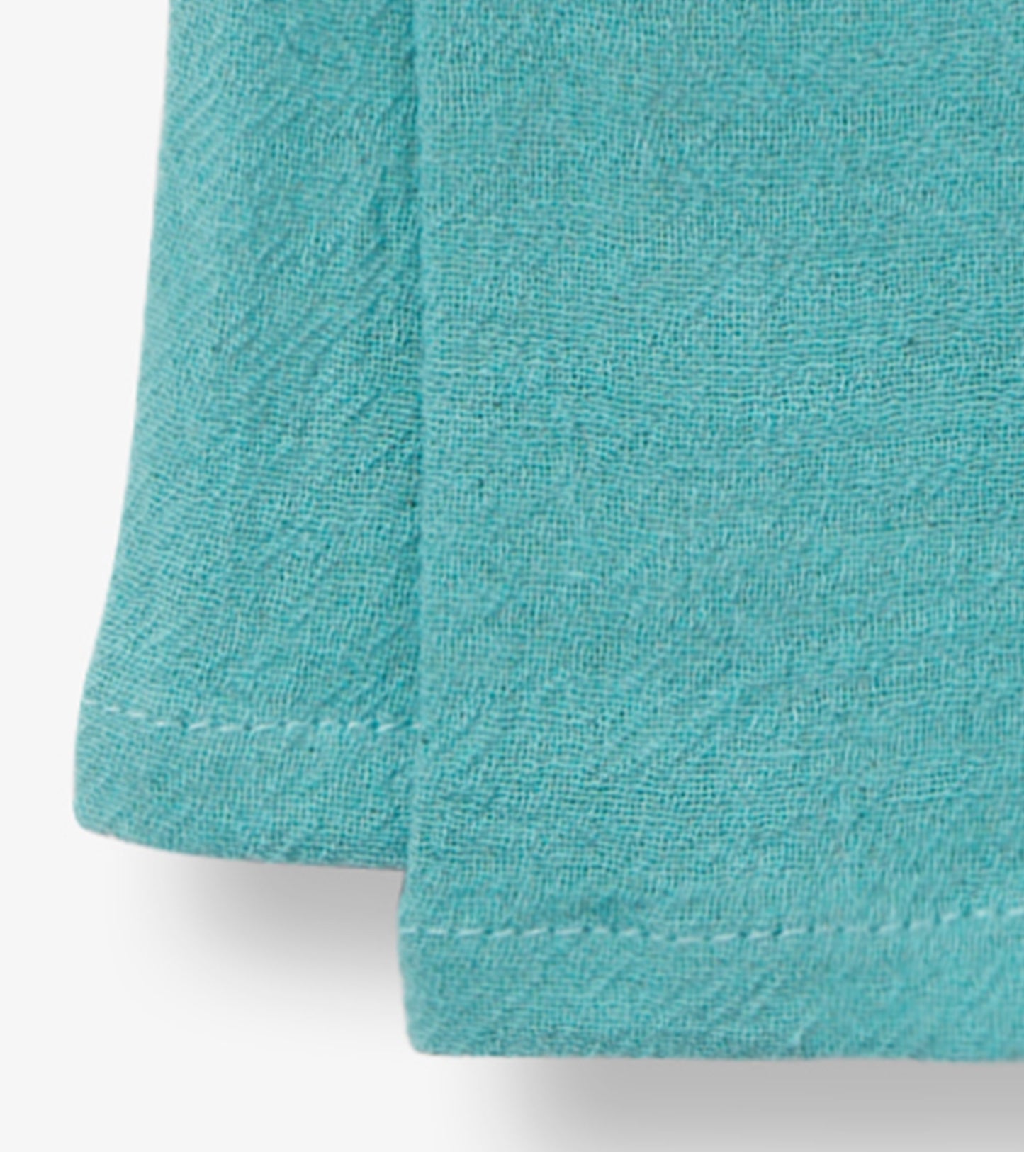Turquoise tea towel with a textured fabric, ideal for kitchen use. Features a folded edge and neat stitching.