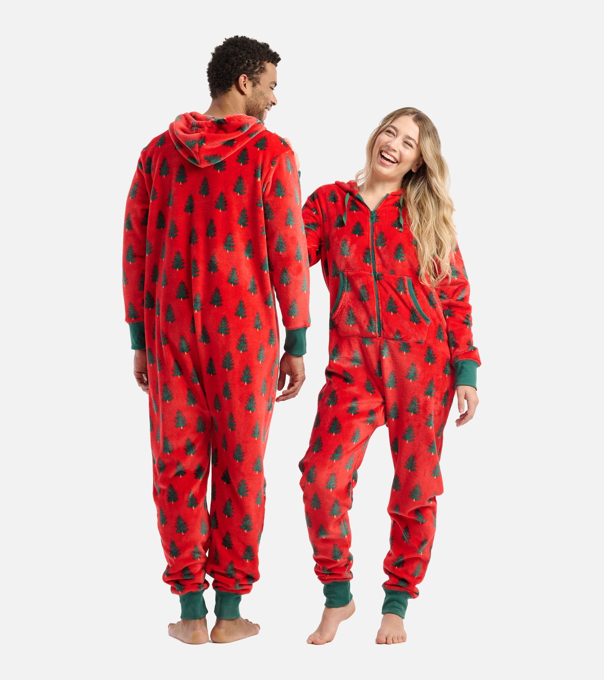 Red fleece jumpsuit featuring a tree pattern, with a hood and green cuffs, worn by a man and woman.
