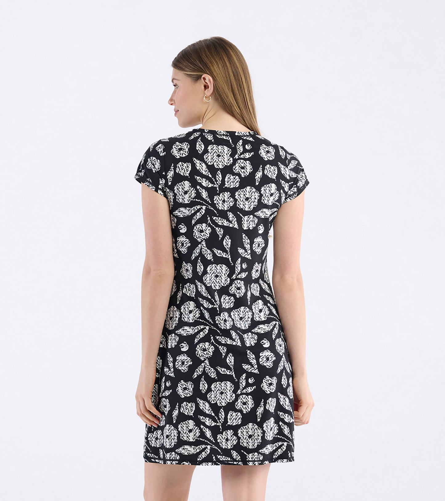 Black t-shirt dress featuring a white floral pattern, short sleeves, and a relaxed fit, shown from the back.