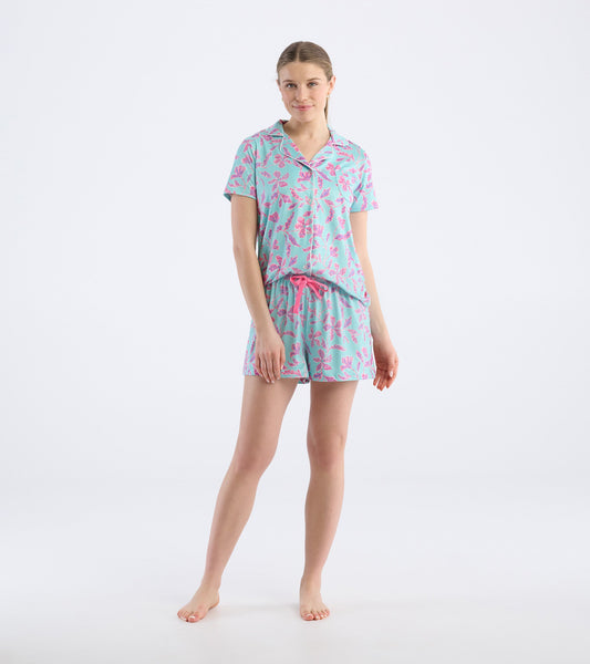 Turquoise short pajama set featuring pink batik flower patterns, with a short-sleeve top and drawstring shorts.
