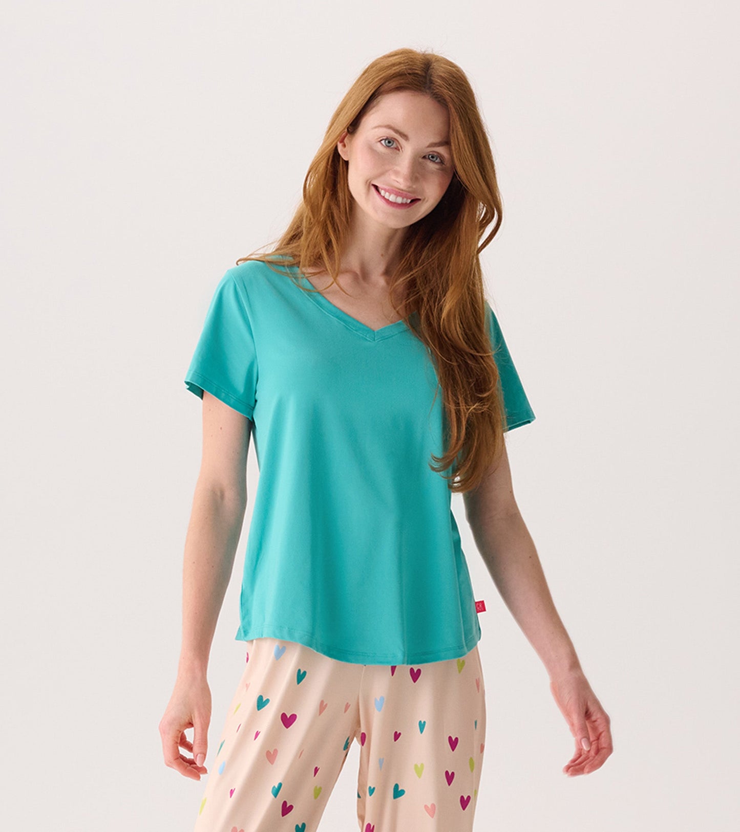Turquoise V-neck T-shirt with short sleeves, paired with patterned pajama pants featuring colorful hearts.