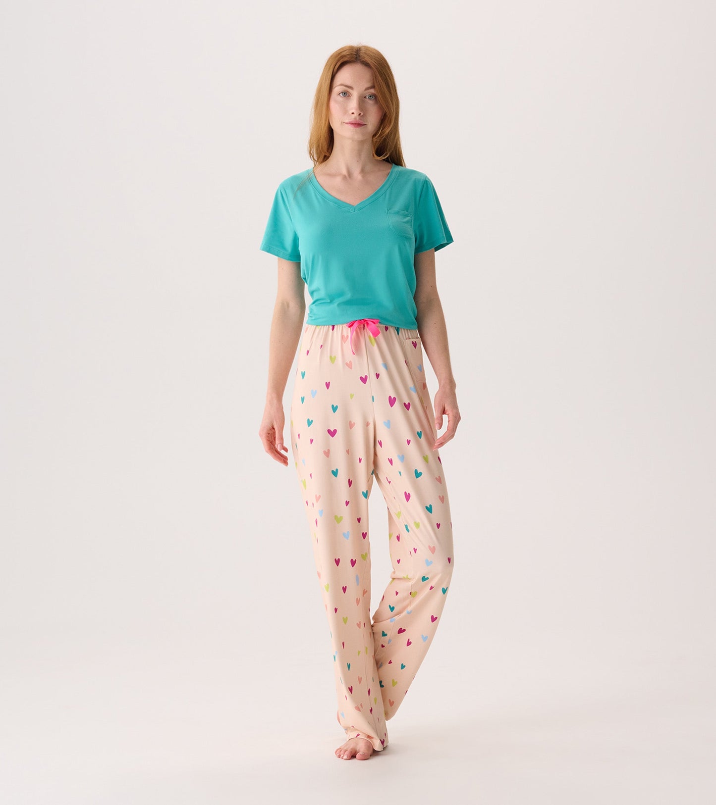 Turquoise V-neck T-shirt paired with light pink pants featuring colorful heart patterns, suitable for casual wear.