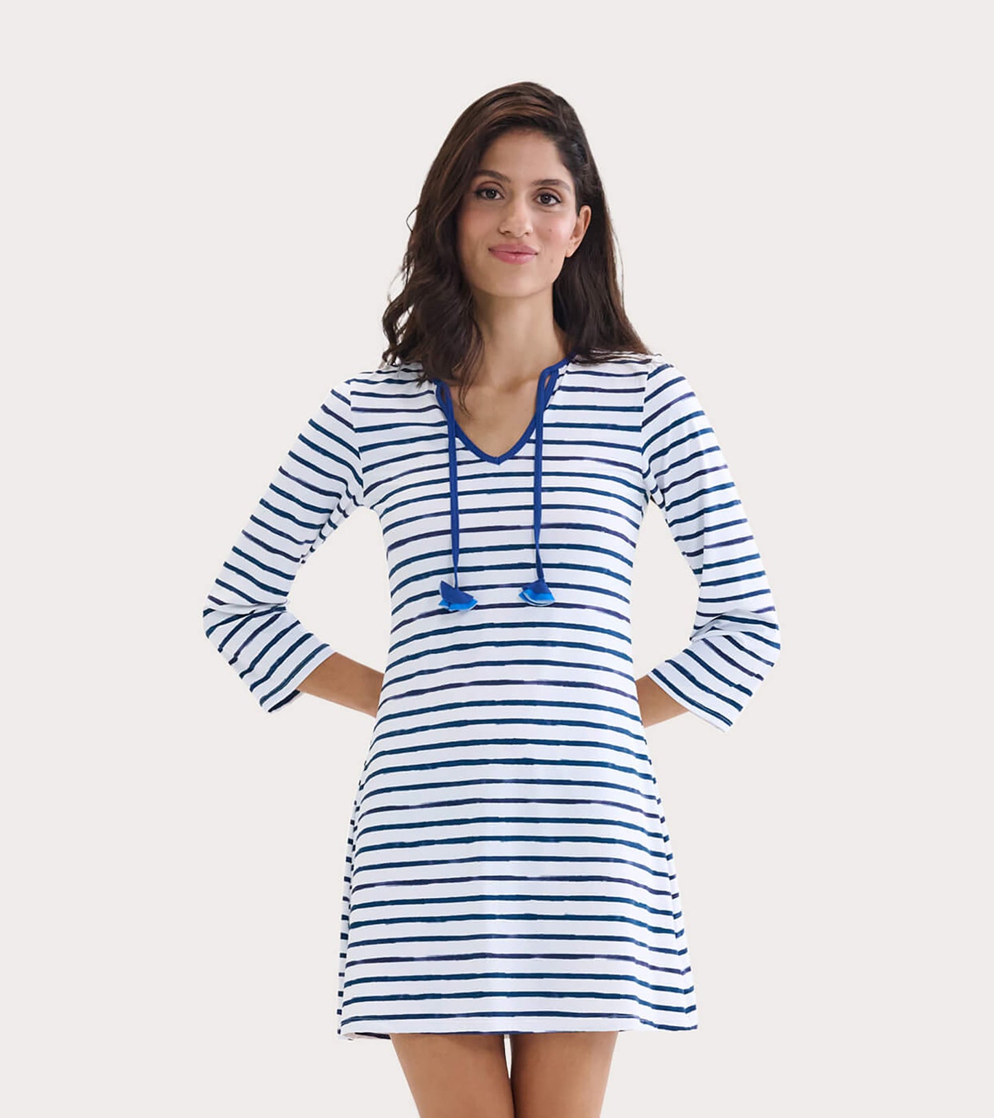 White dress with navy stripes, V-neck, and drawstring detail, perfect for beachwear.