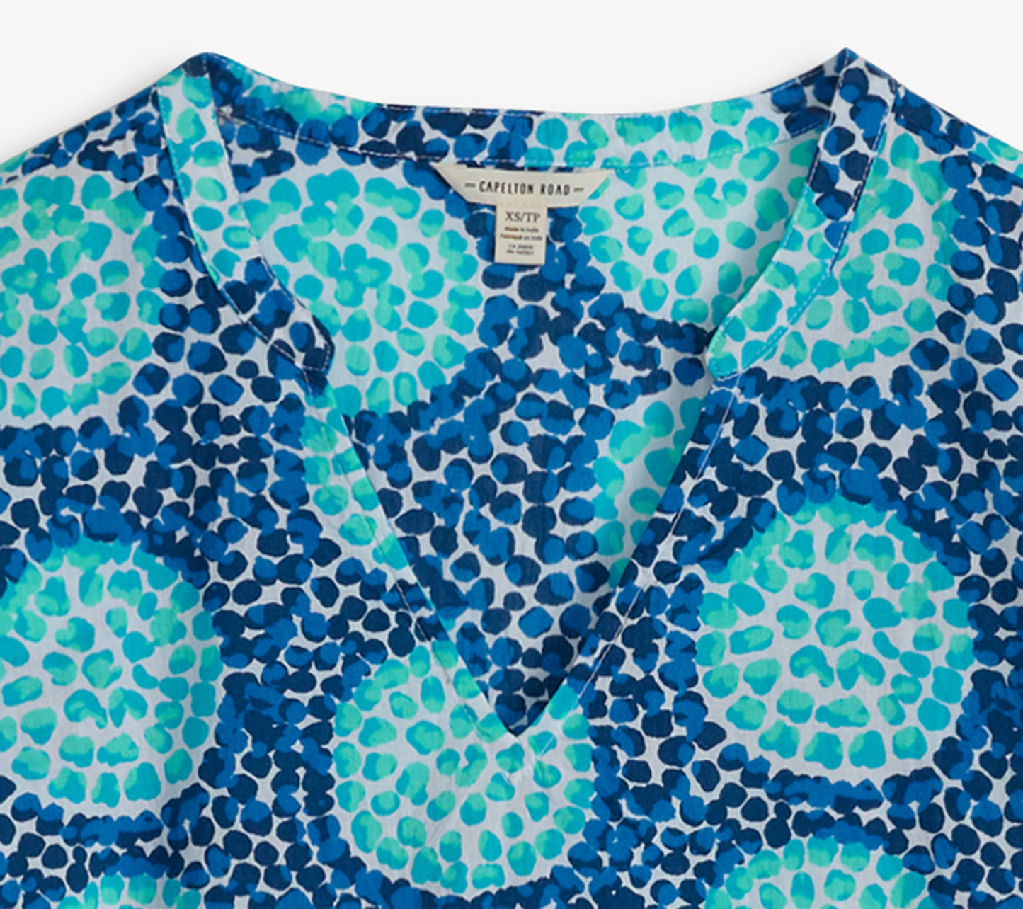 Blue and turquoise tunic featuring a vibrant abstract pattern and a V-neckline.