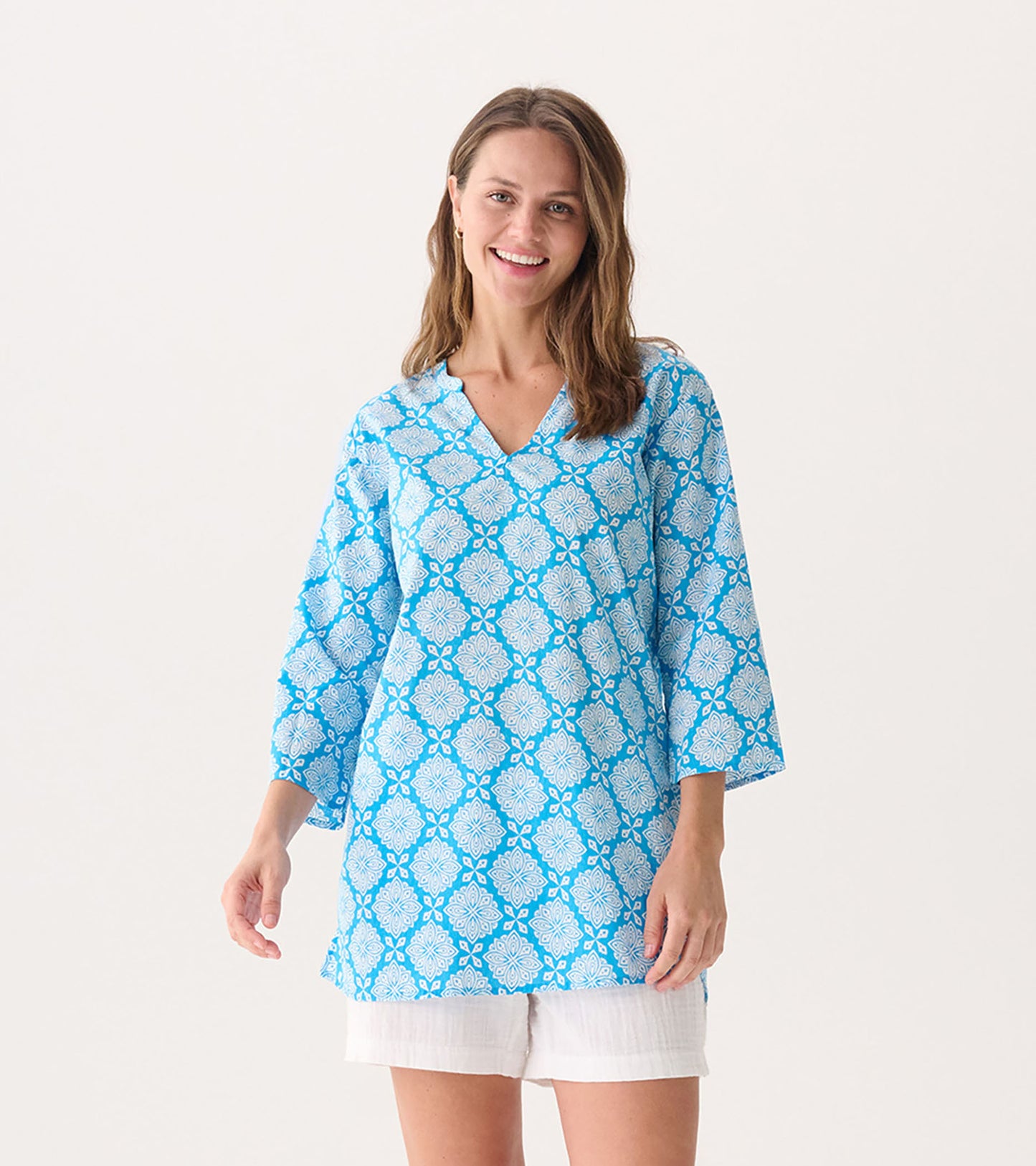 Blue tunic featuring a gradient floral pattern and three-quarter sleeves, perfect for casual wear.