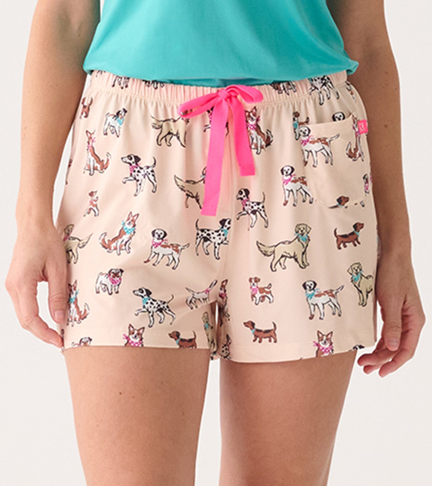 Light pink pajama shorts featuring a playful dog print and a pink drawstring, ideal for casual lounging.