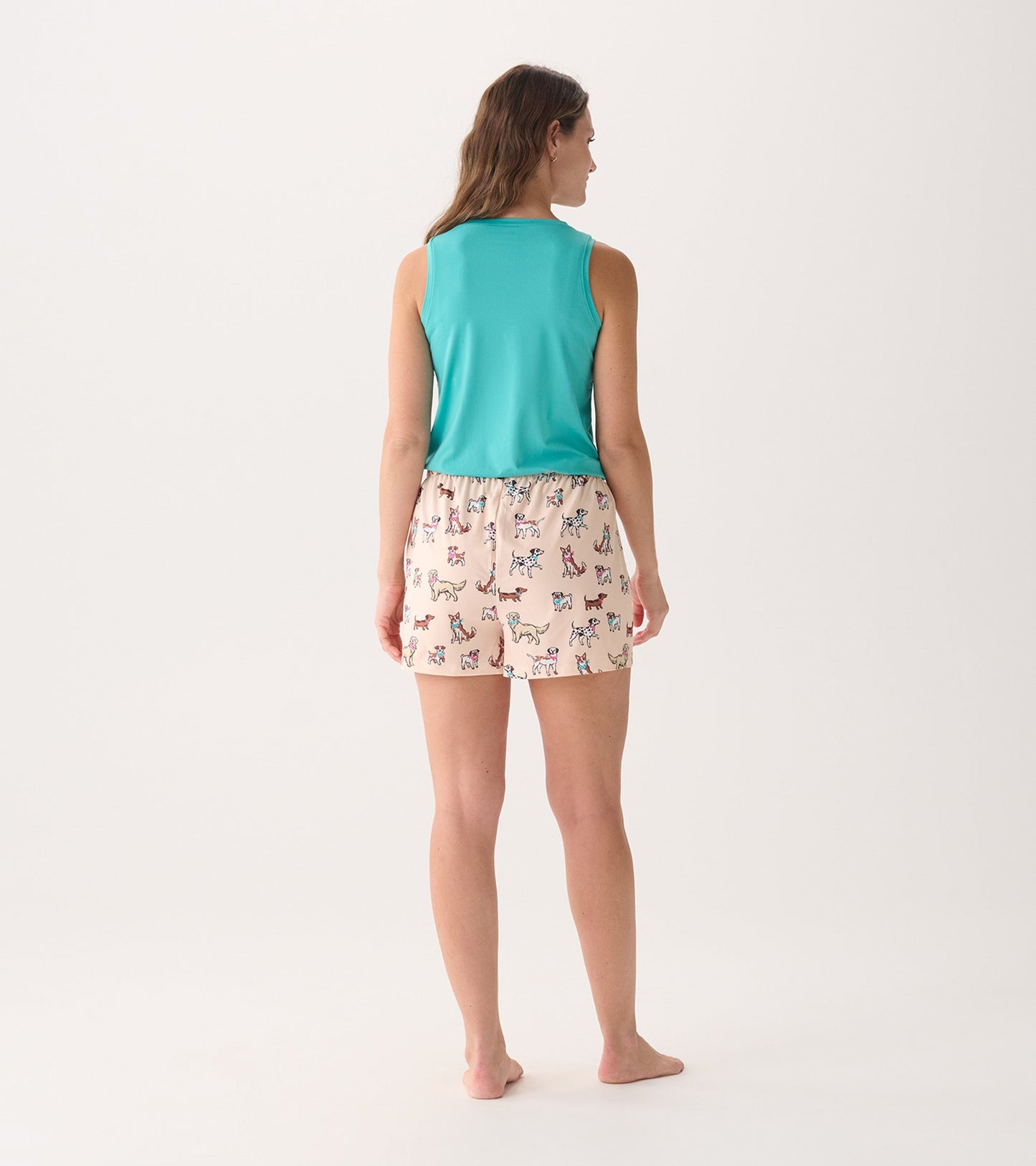 Back view of women's pajama set featuring a teal sleeveless top and light pink shorts with colorful dog prints.