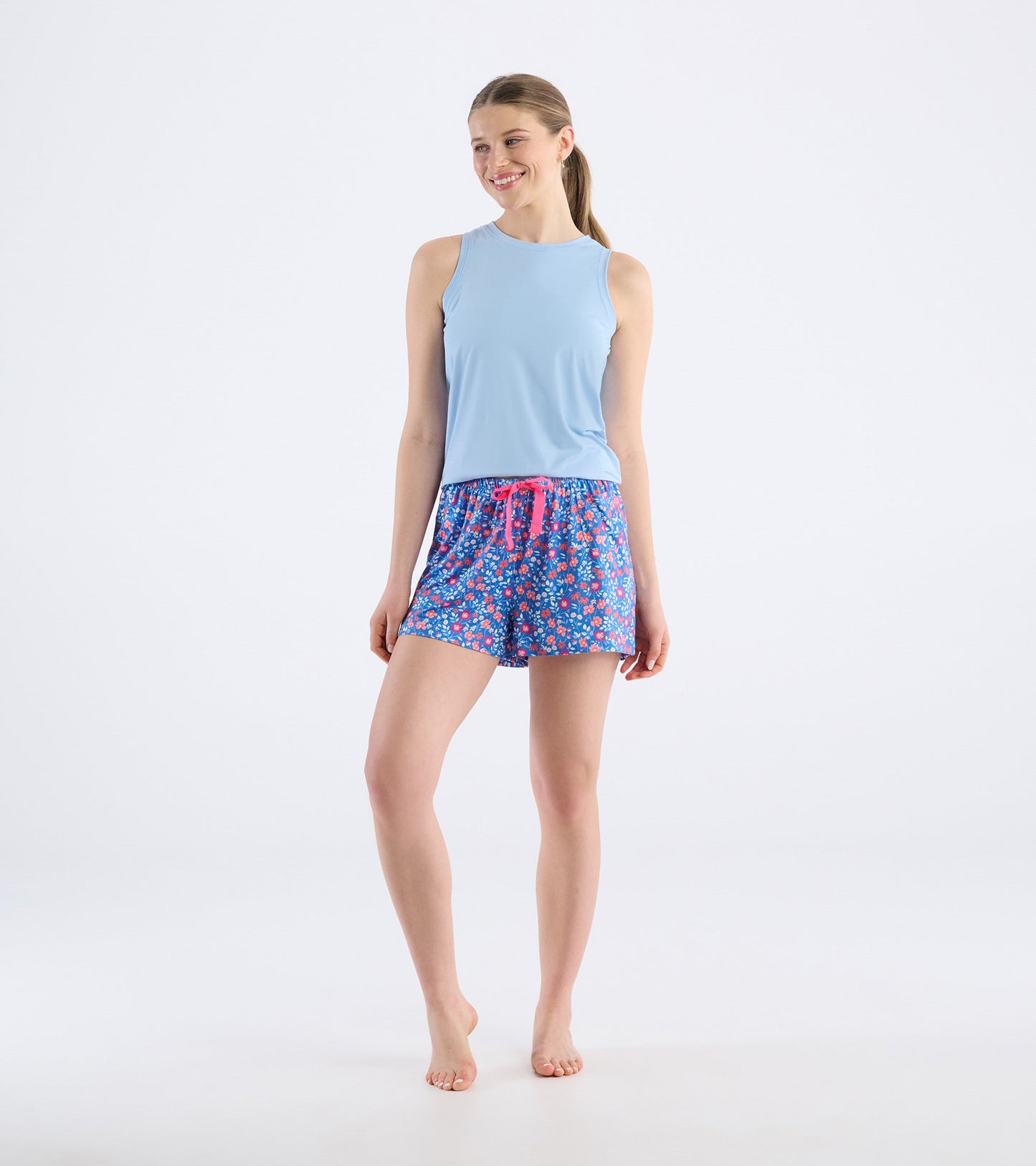 Light blue sleeveless top paired with colorful floral pajama shorts featuring a pink drawstring.