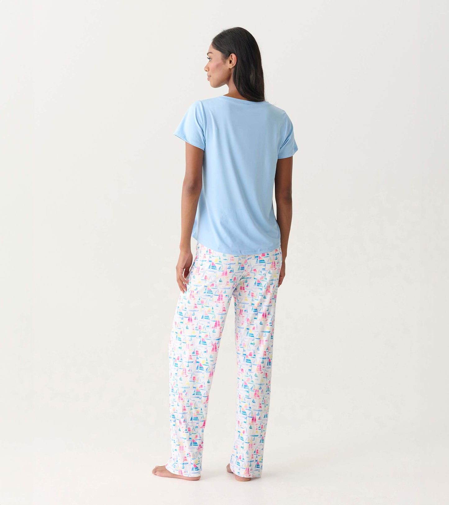 Light blue polyknit V-neck T-shirt worn with patterned pajama pants, viewed from the back.
