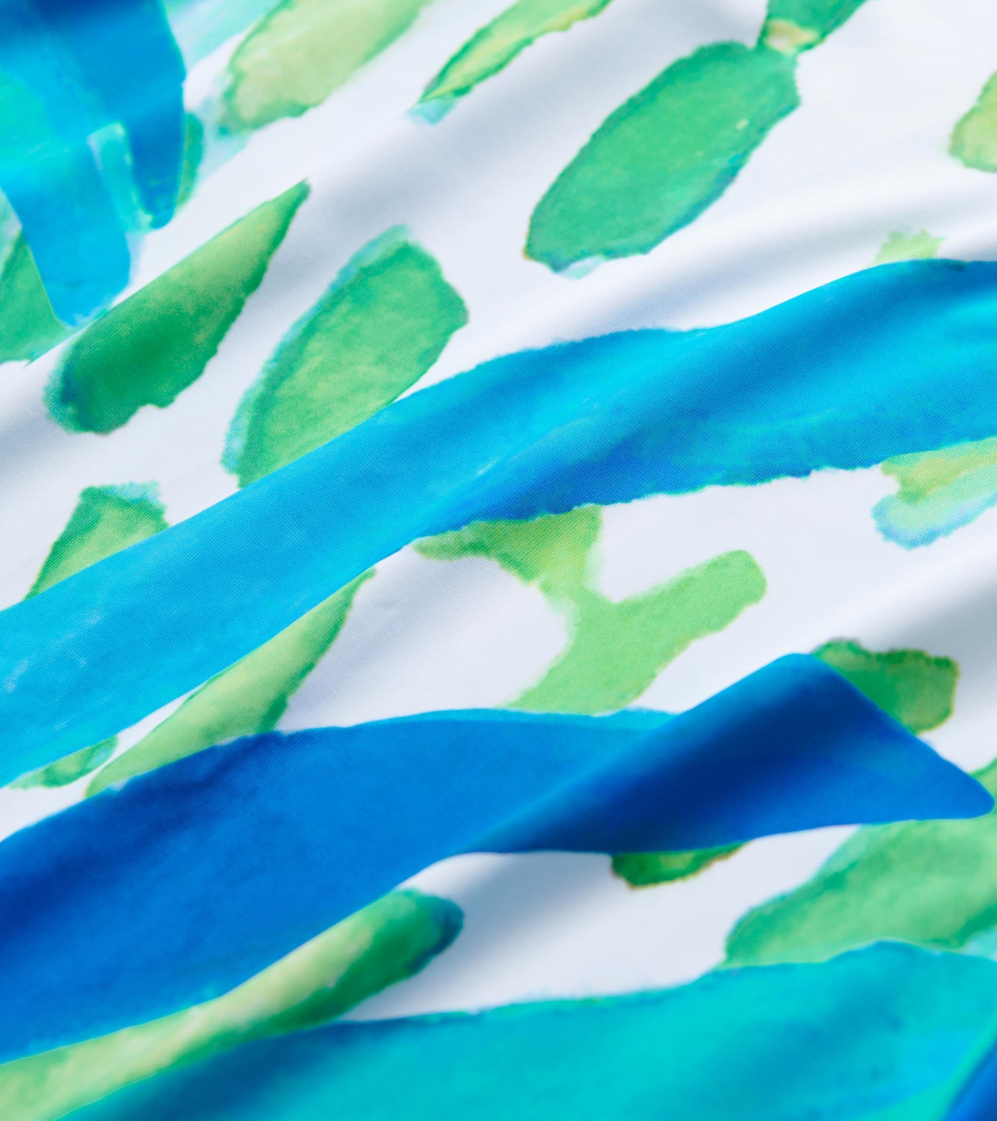 Colorful watercolor pattern featuring blue and green strokes on a white fabric, suitable for a casual summer dress.