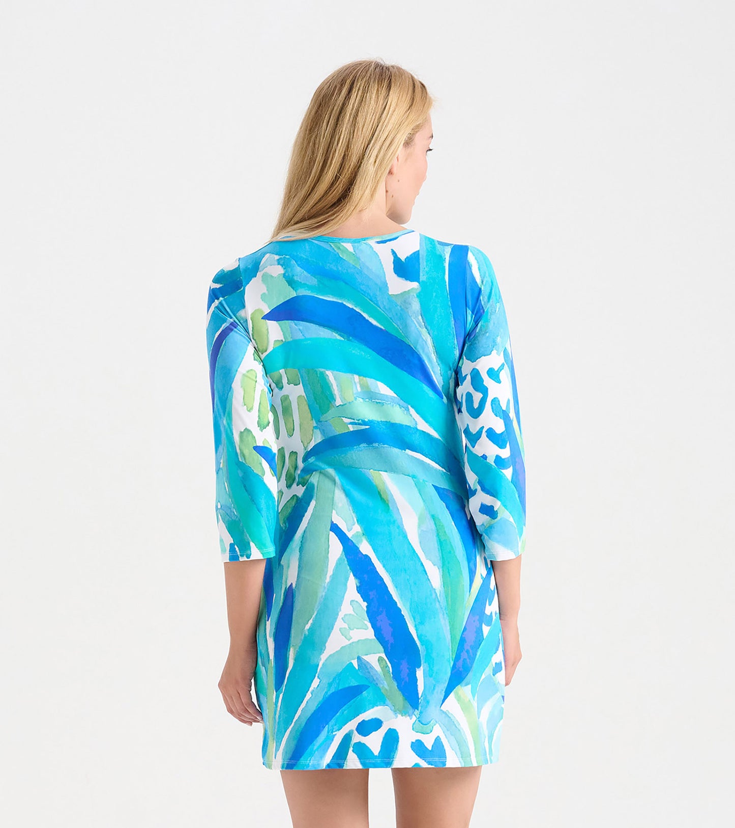 Back view of a women's dress featuring a vibrant blue and green tropical leaf pattern, with three-quarter sleeves.
