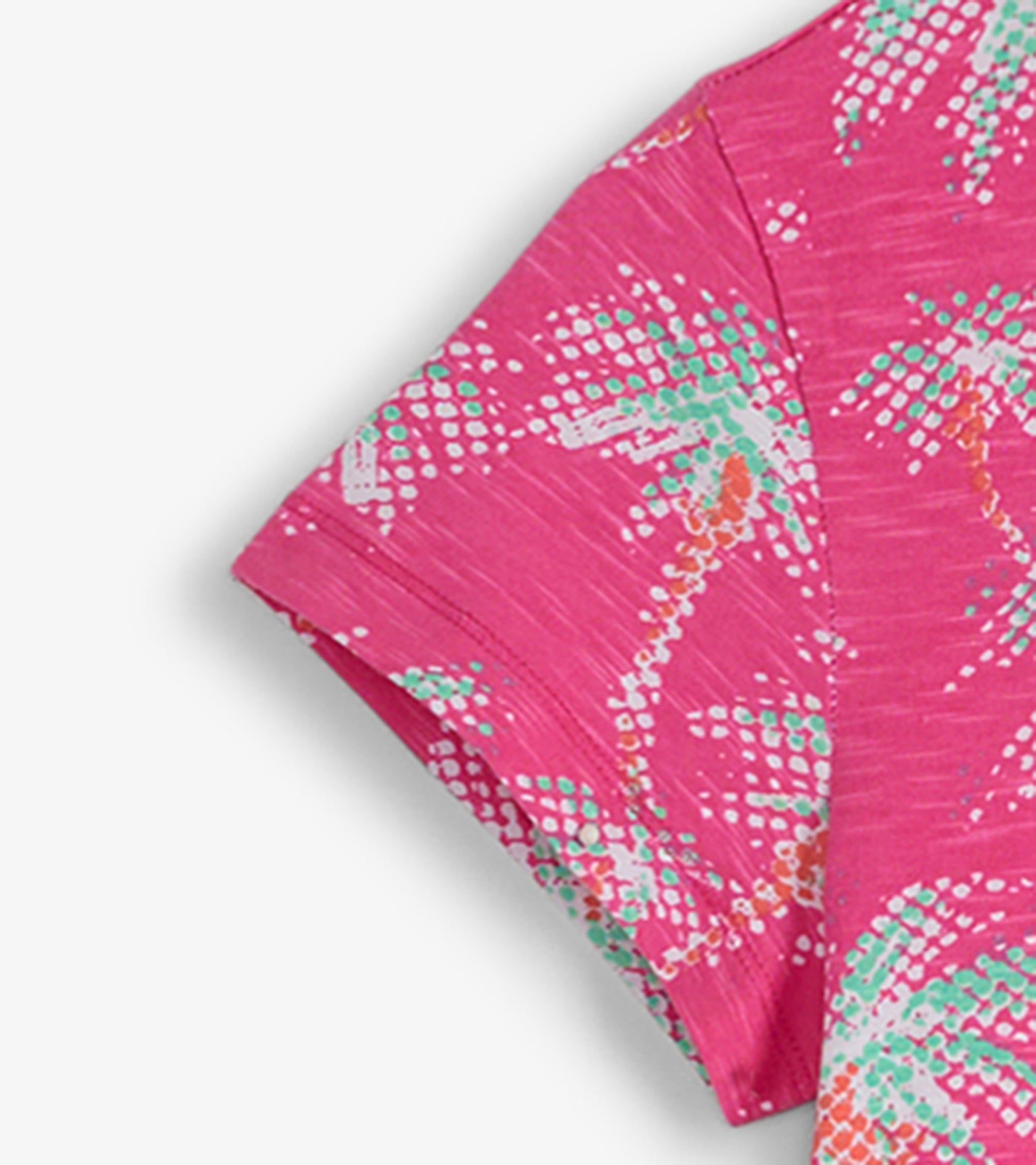 Pink crew neck t-shirt dress featuring a palm tree pattern in green and white, with short sleeves and a relaxed fit.