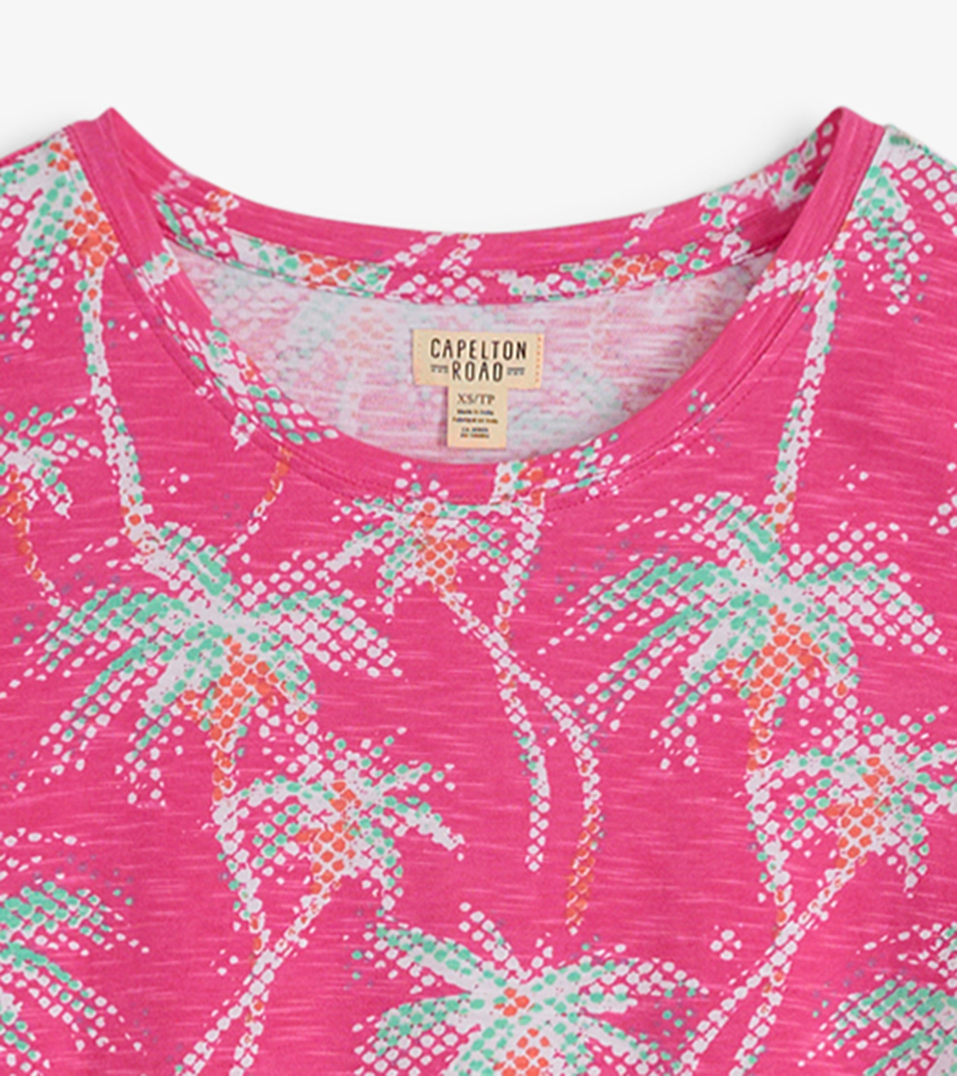 Pink crew neck t-shirt dress featuring a palm tree pattern in green and orange hues.