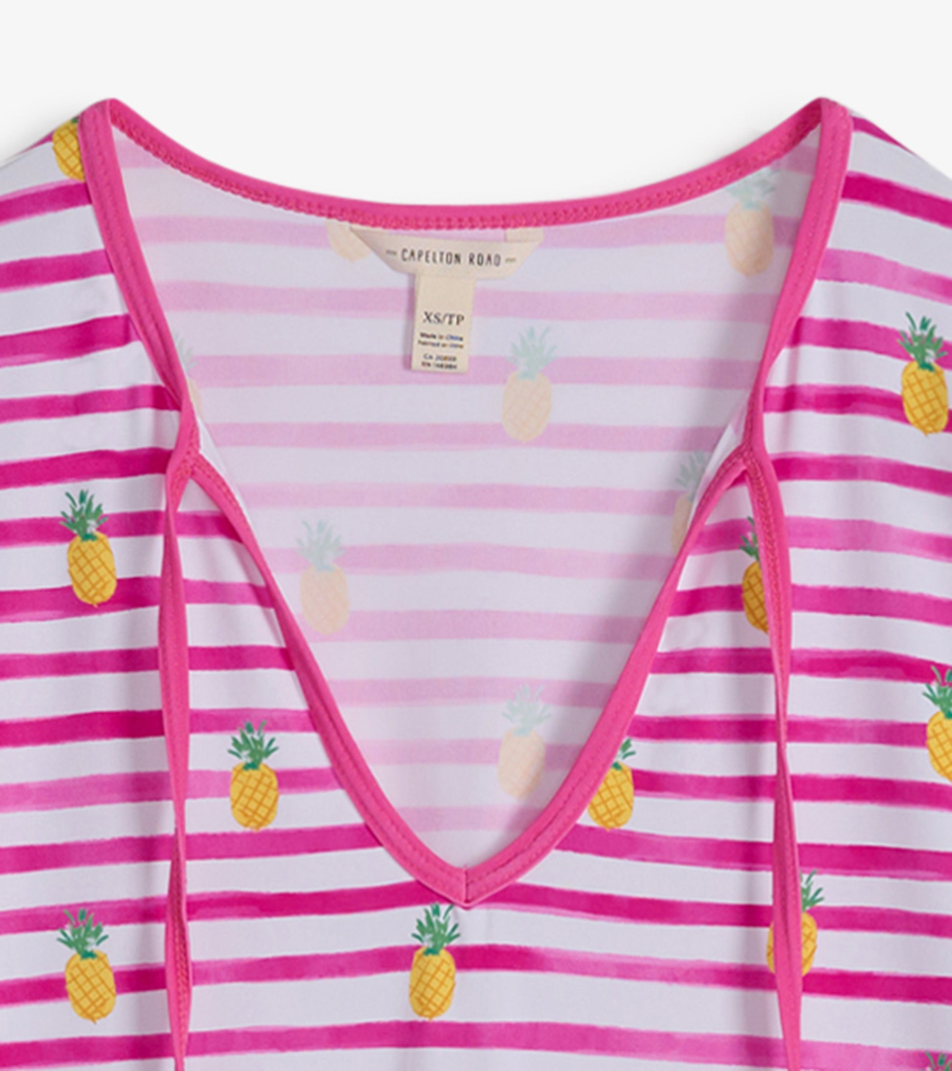 Pink and white striped beach dress featuring pineapple prints and a V-neckline.