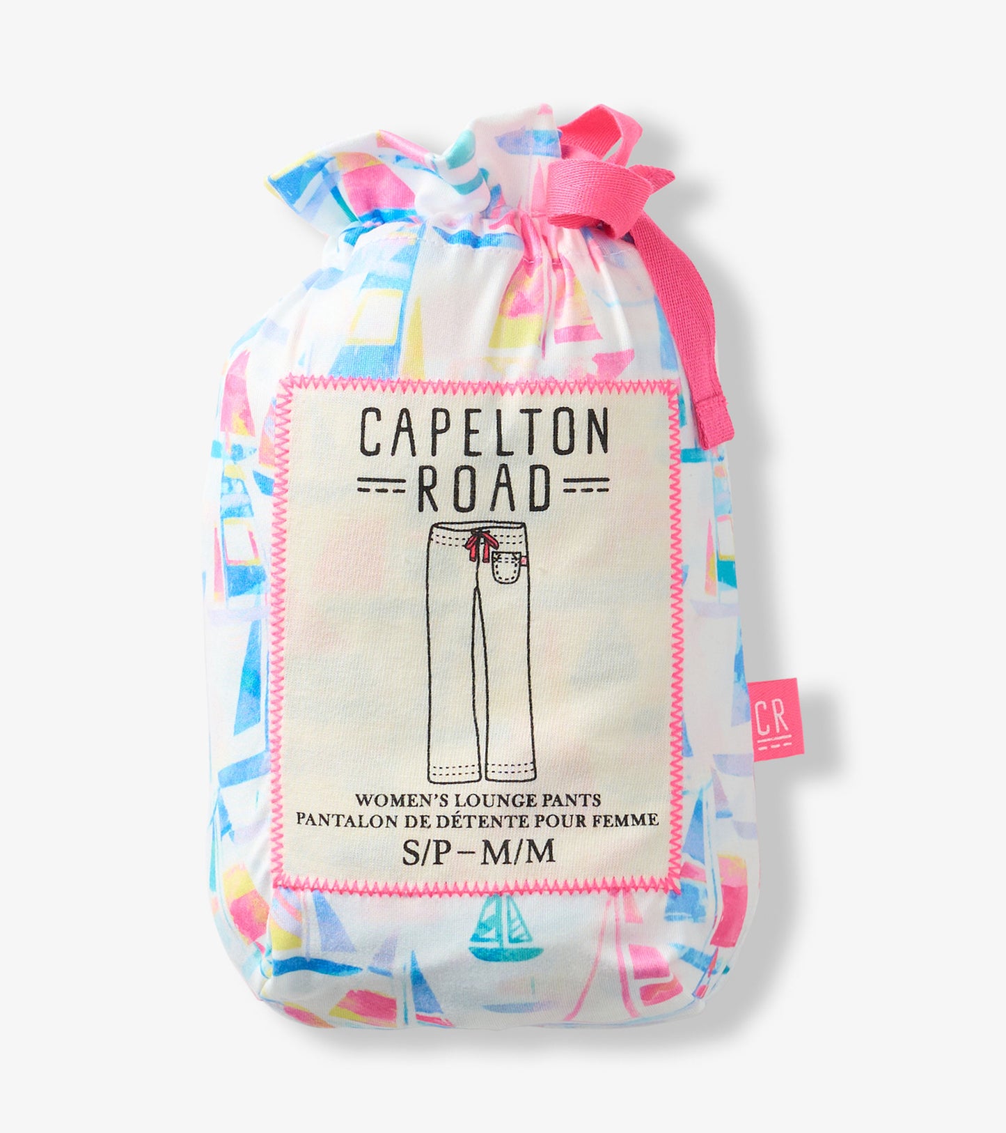 Folded white pajama pants with colorful sailboat print, packaged in a drawstring pouch with pink trim.