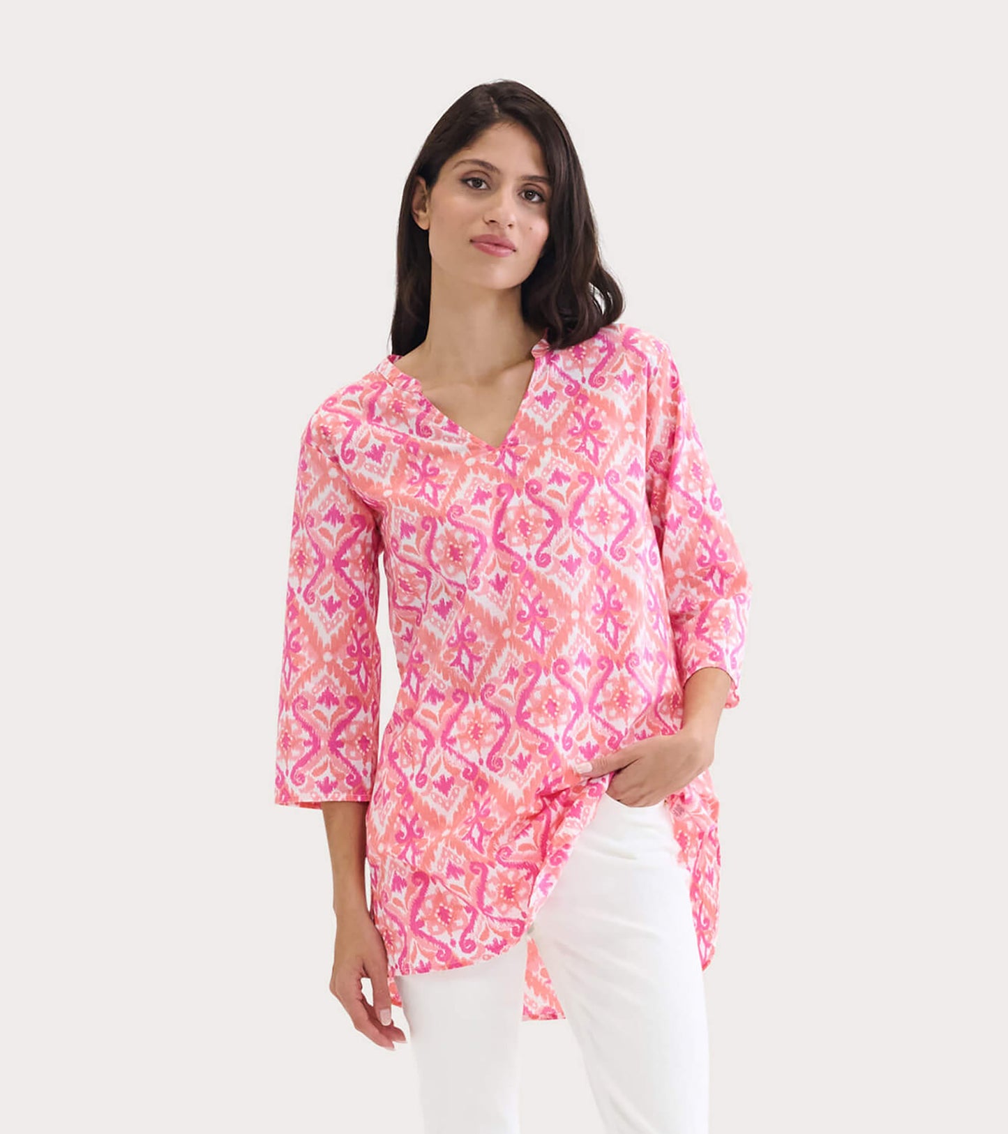 Pink ikat tunic with a V-neck and three-quarter sleeves, featuring a flowing silhouette and side slits.