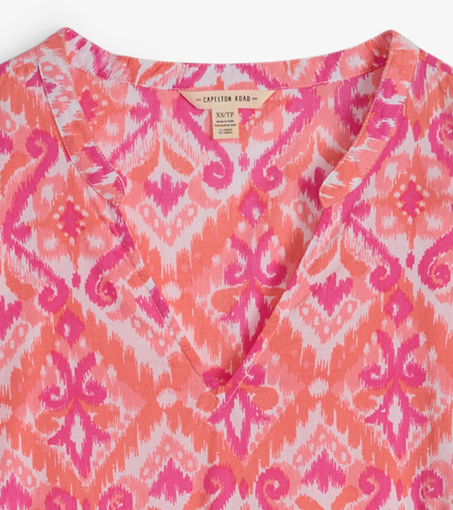 Pink and orange ikat patterned tunic with a V-neckline, suitable for casual wear.