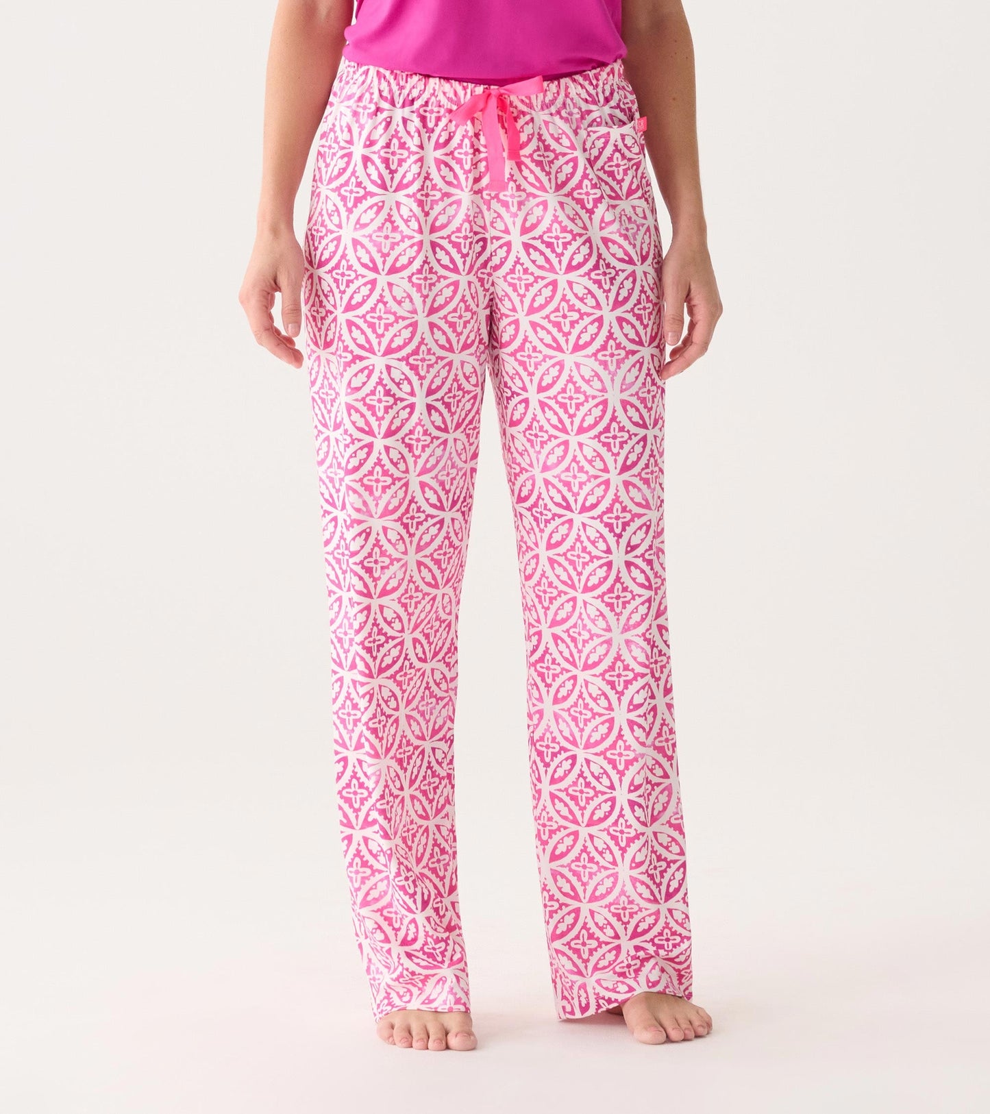 Pink polyknit pajama pants featuring a lotus mandala pattern and an elastic waistband with a drawstring.