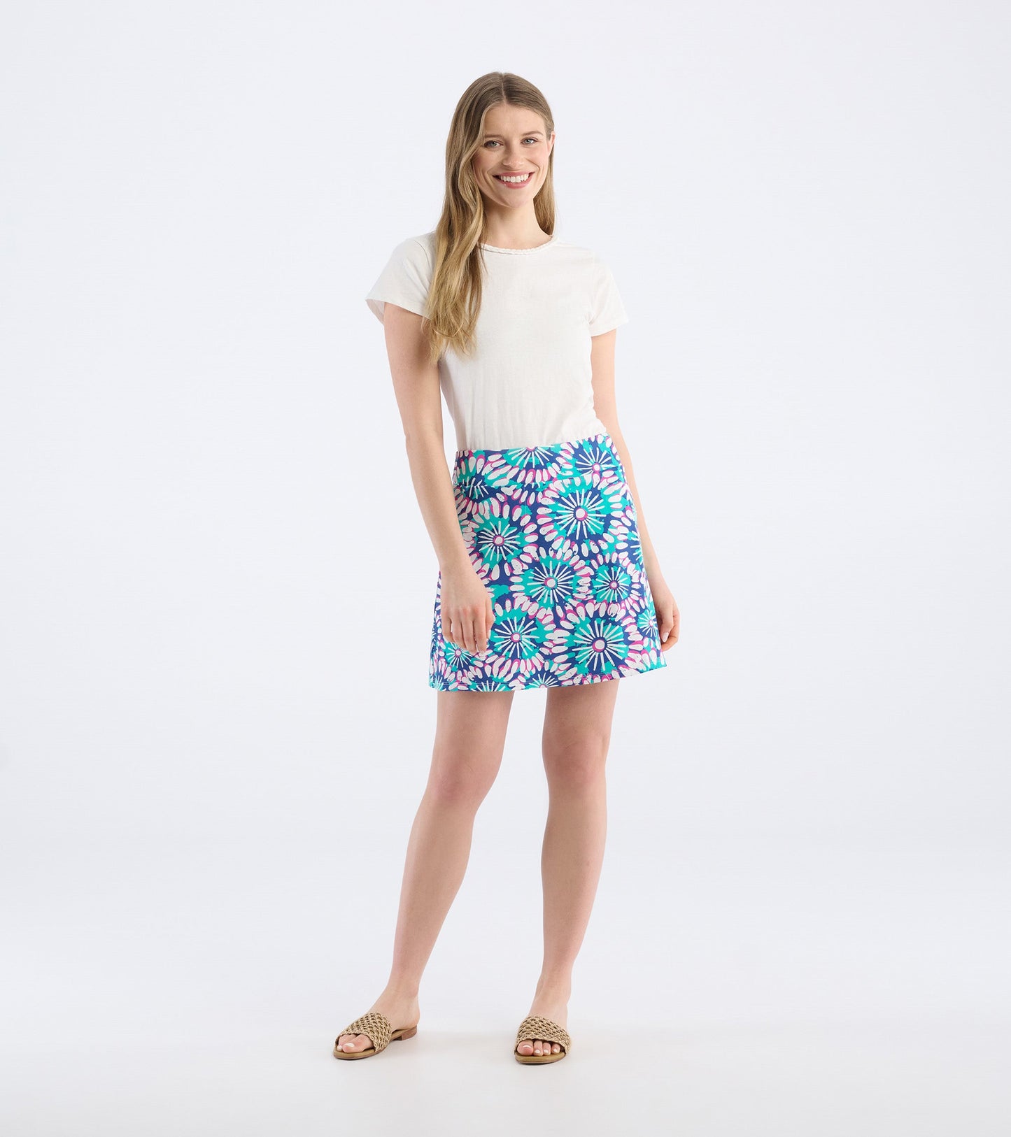 Colorful floral-patterned skort in blue, featuring pink and green accents, styled with a white top and sandals.
