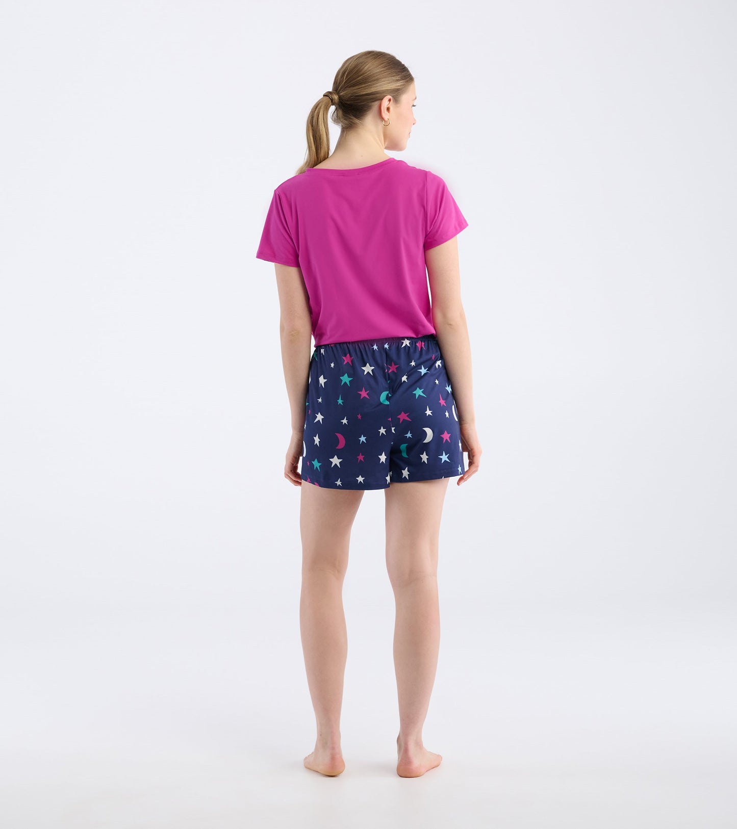 Navy pajama shorts with colorful star and moon pattern, featuring an elastic waistband, shown from the back.