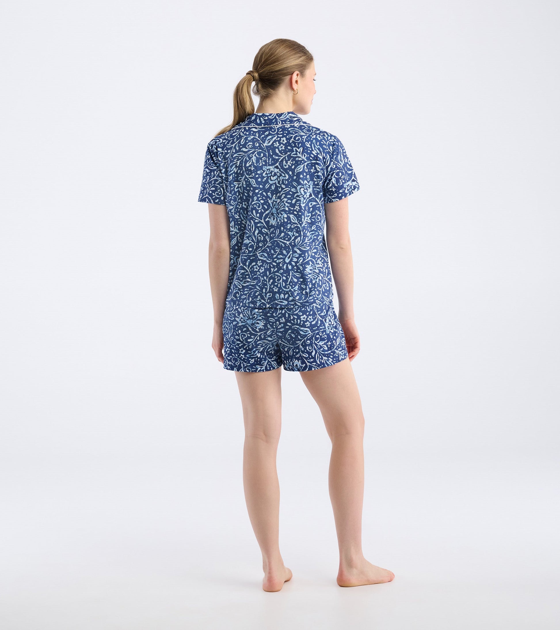 Short pajama set featuring a blue batik floral pattern, with a short-sleeve top and matching shorts, viewed from the back.