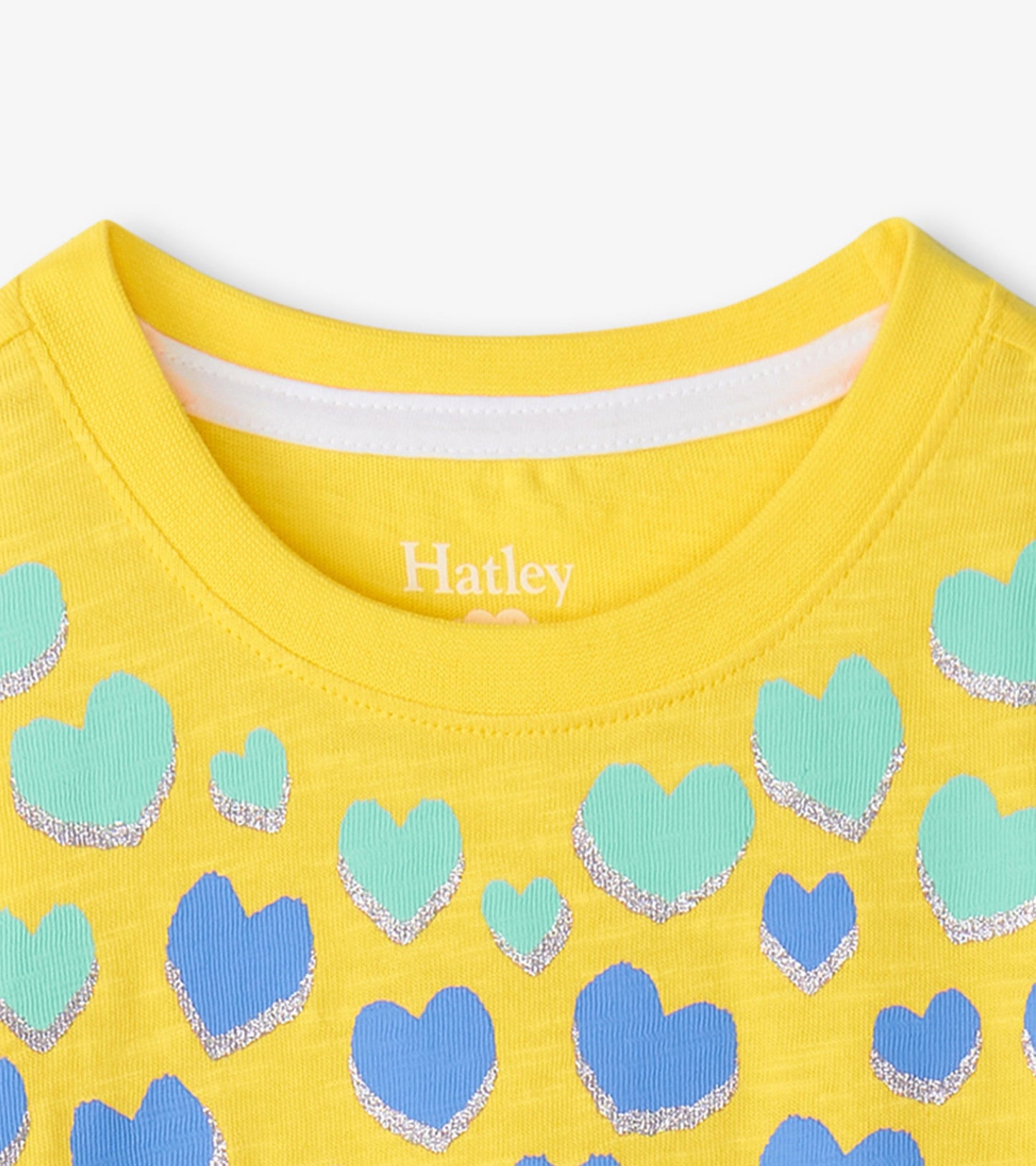 Yellow graphic tee featuring various hearts in blue and green with silver accents, showcasing a round neckline.
