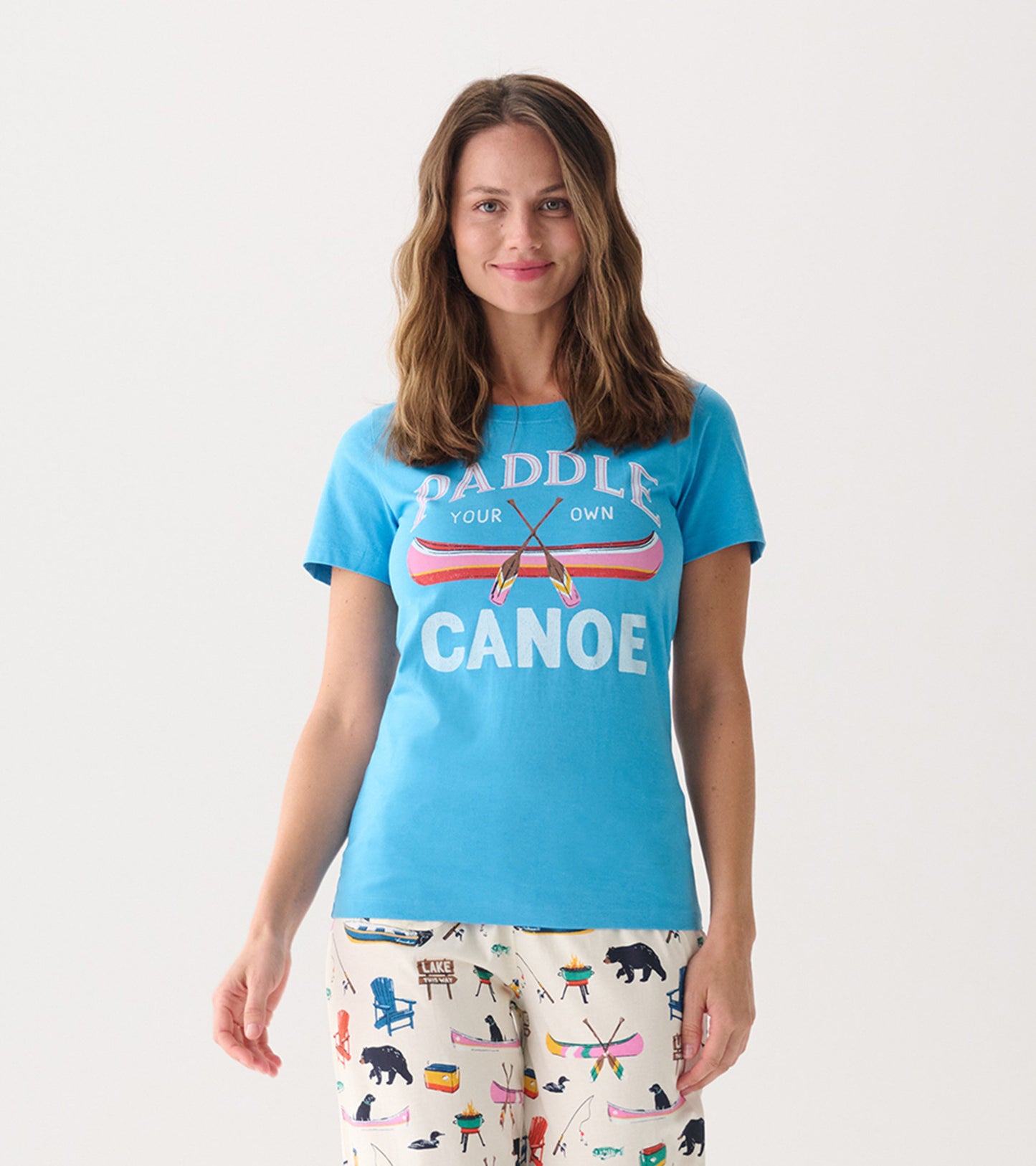 Light blue women's pajama t-shirt featuring a canoe graphic and playful text, paired with patterned pajama pants.