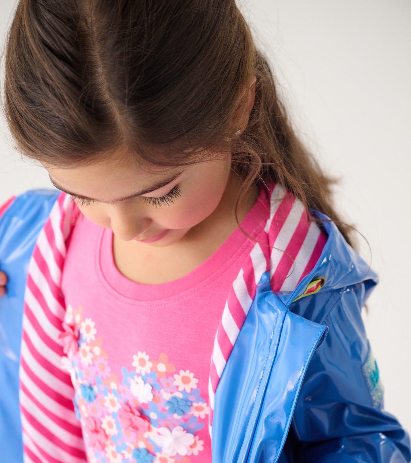 Blue glitter swing jacket with a shiny finish, worn over a pink floral shirt, featuring a striped inner lining.