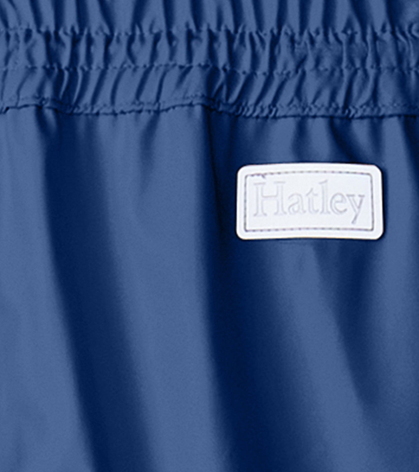 Navy blue kids' rain pants with elastic waistband, made from waterproof material, ideal for wet weather play.